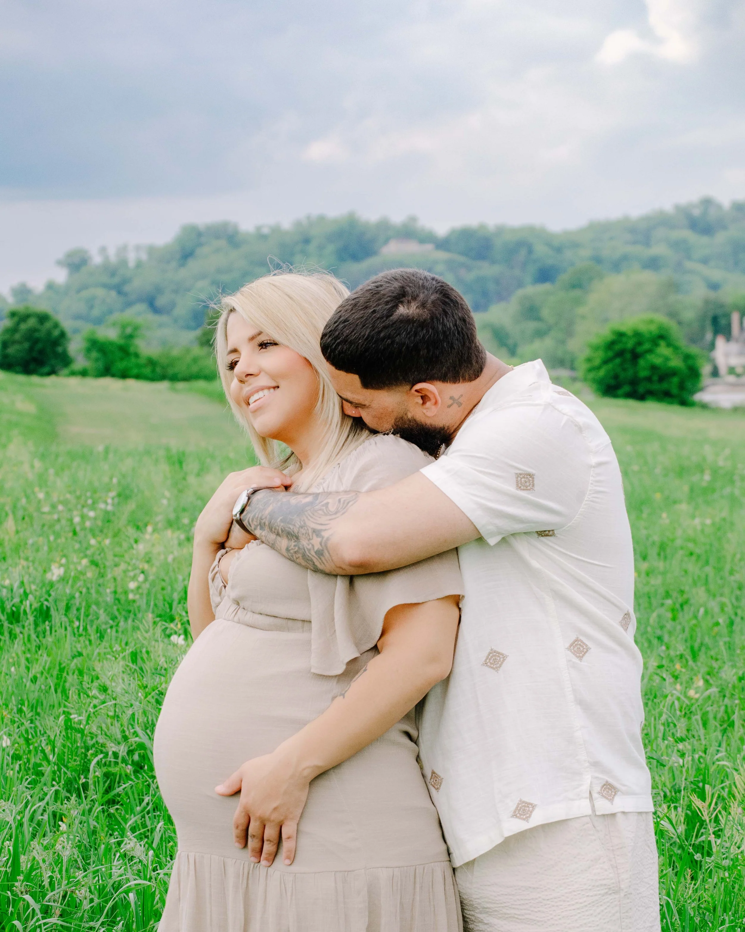 Husband and pregnant wife smiling at each other at Ut Research in Knoxville, Maryville maternity photographer
