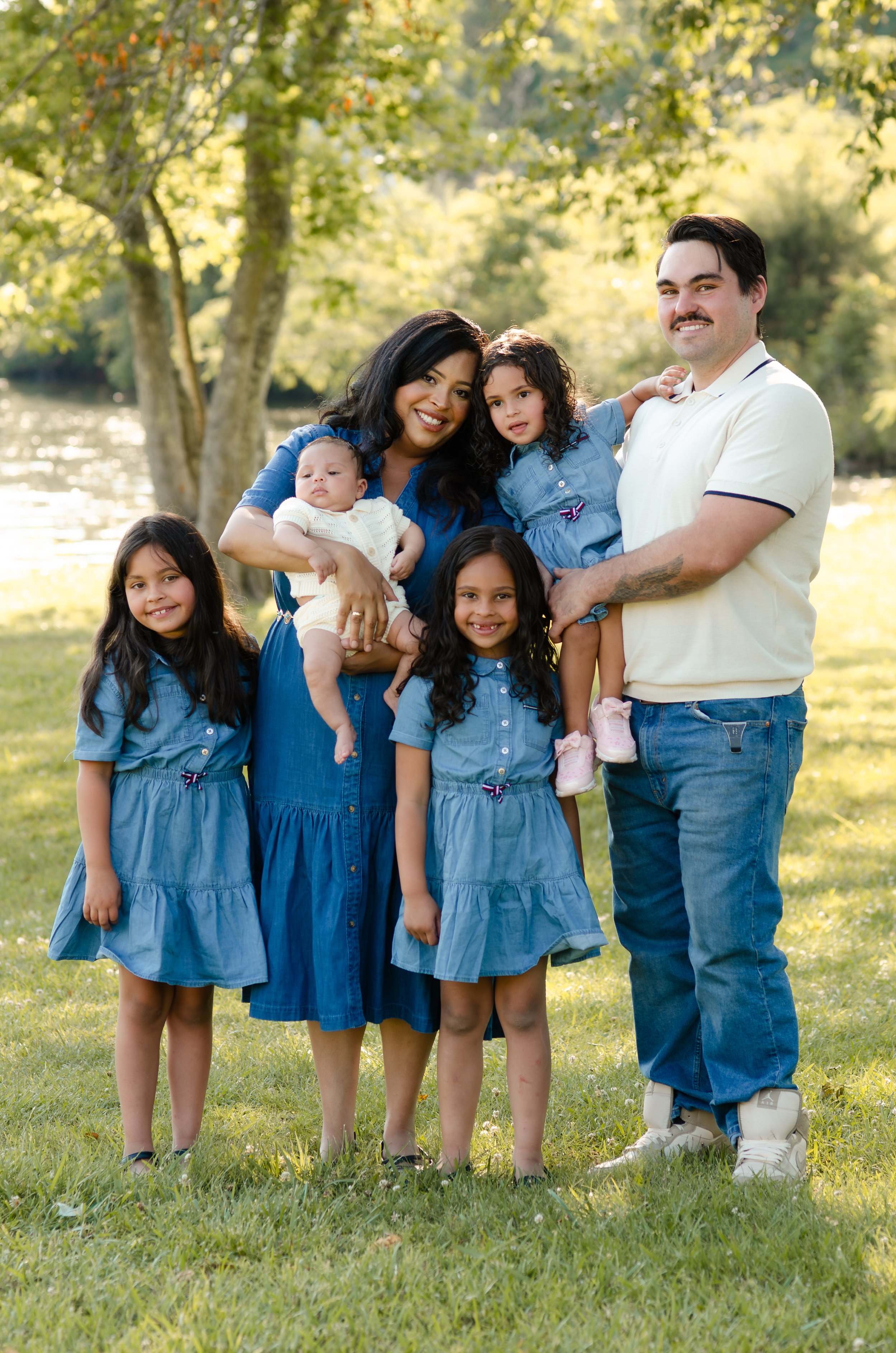 Family photography session in Maryville with active kids running and parents holding newborn