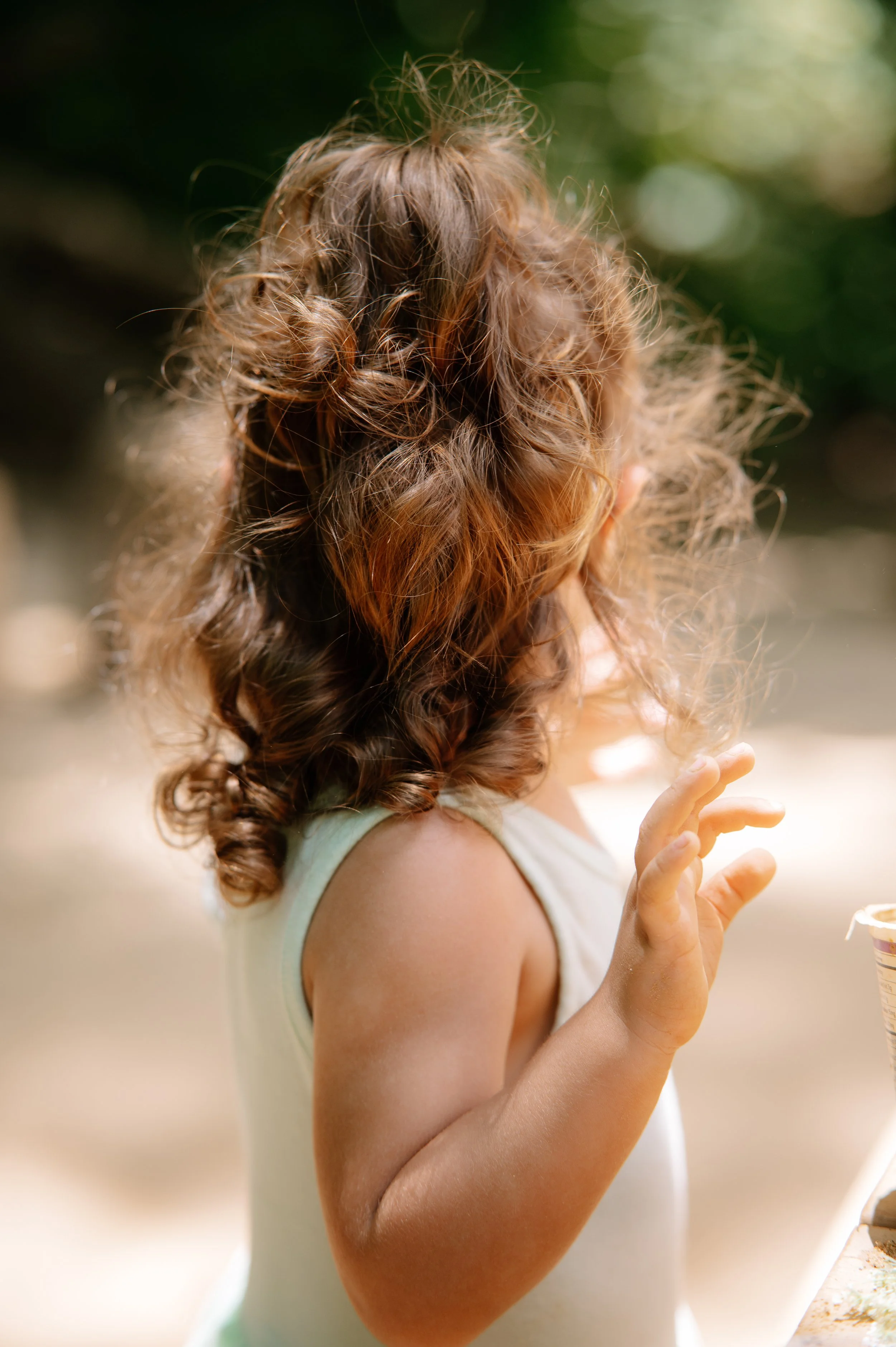 Playful outdoor portrait of a little girl exploring a mud kitchen in the woods near Knoxville TN