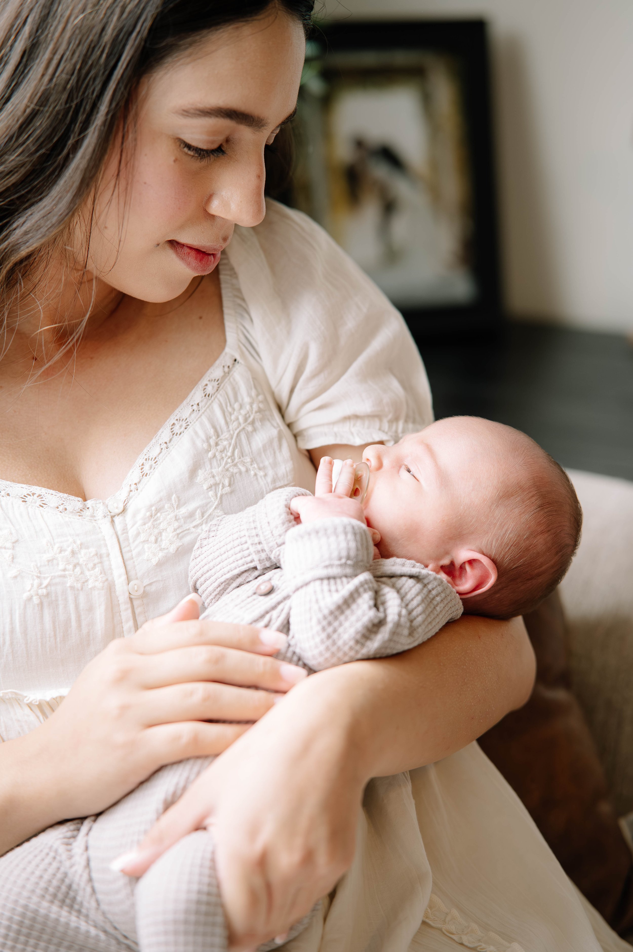 Mom holding her newborn baby in her arms during an in home newborn session in Knoxville Tn