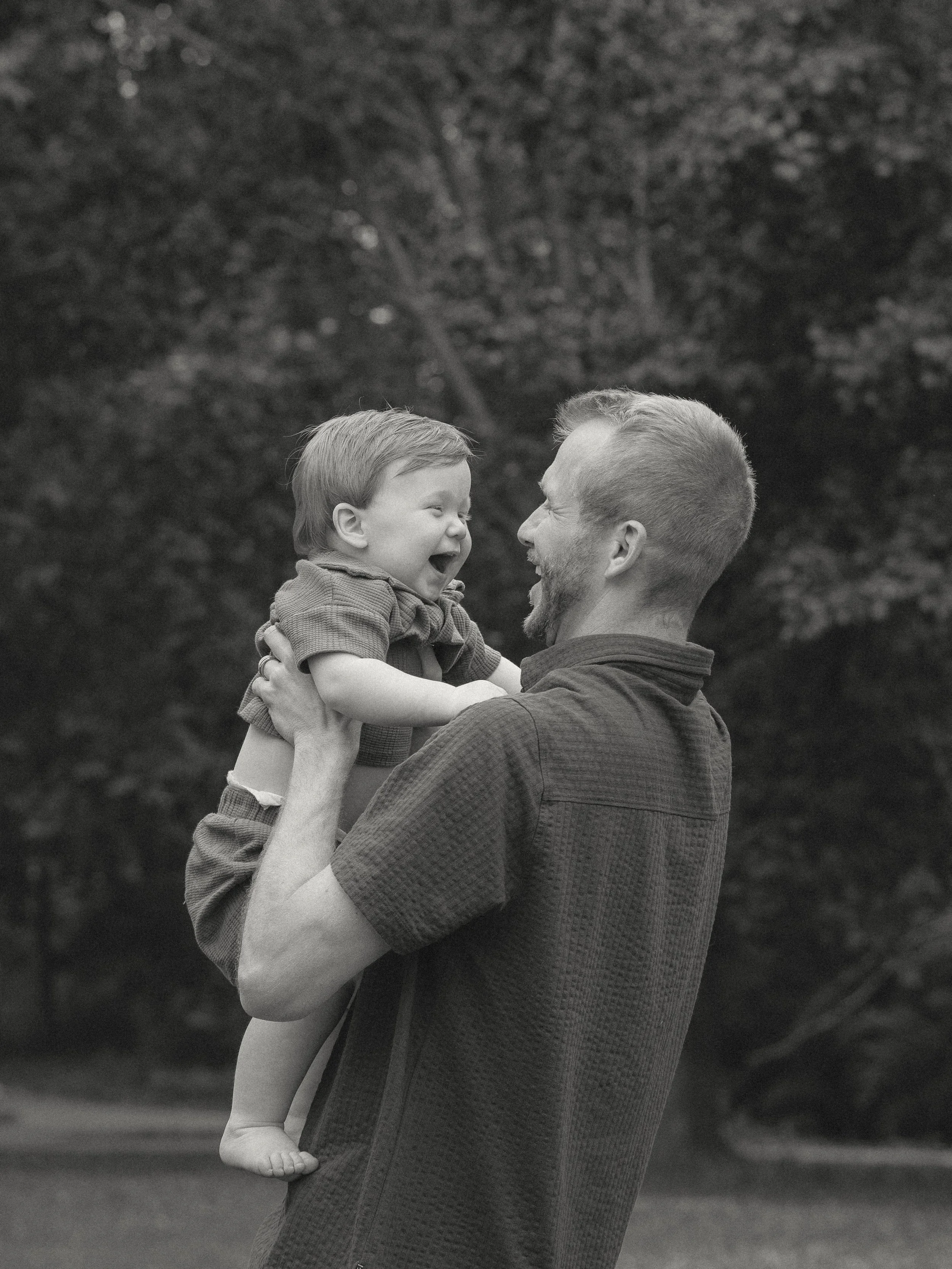 Parents lifting their toddler into the air during sunset family photos