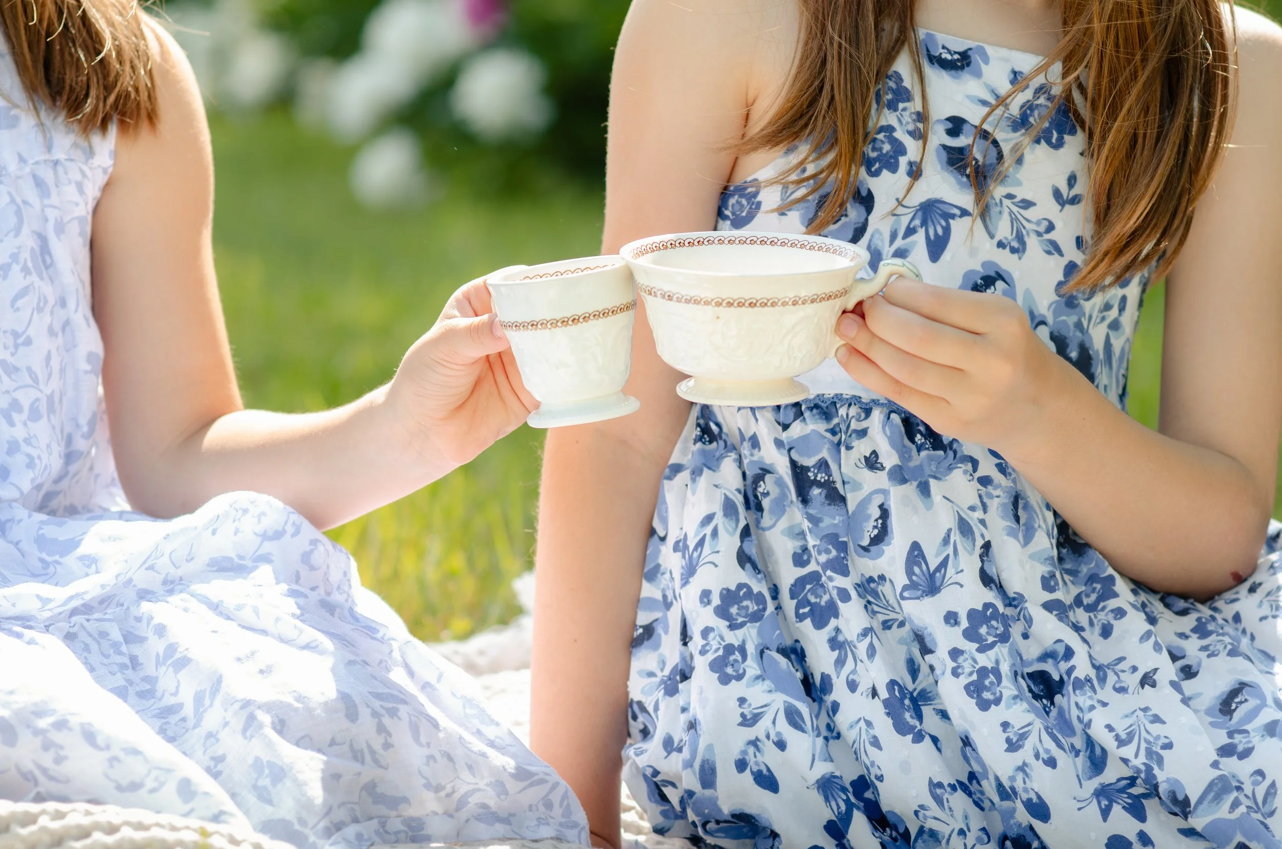 Sisters photos in Knoxville with tall trees and natural, playful tea party photo session.
