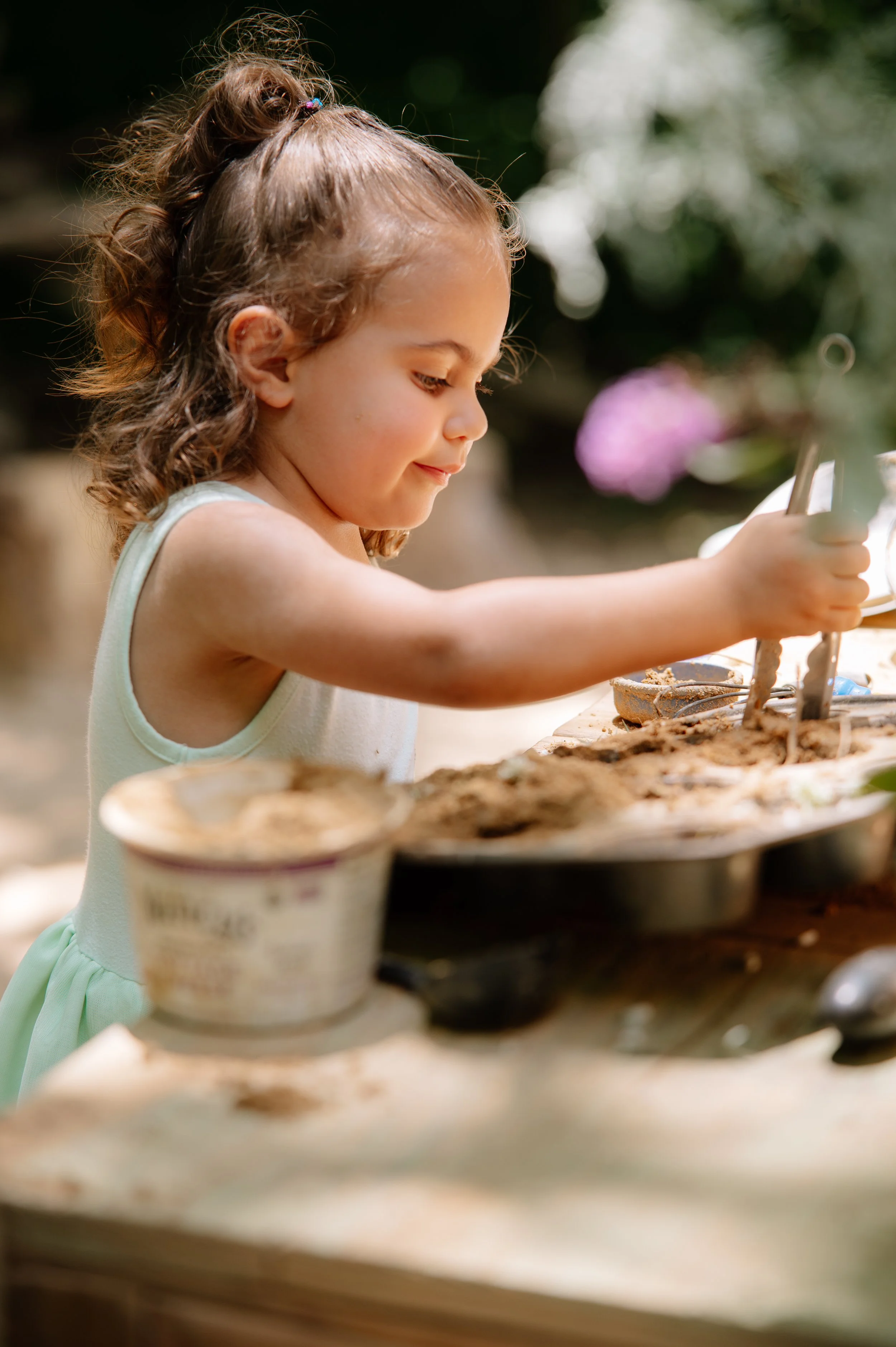 Young girl exploring nature while playing at a rustic mud kitchen in East Tennessee