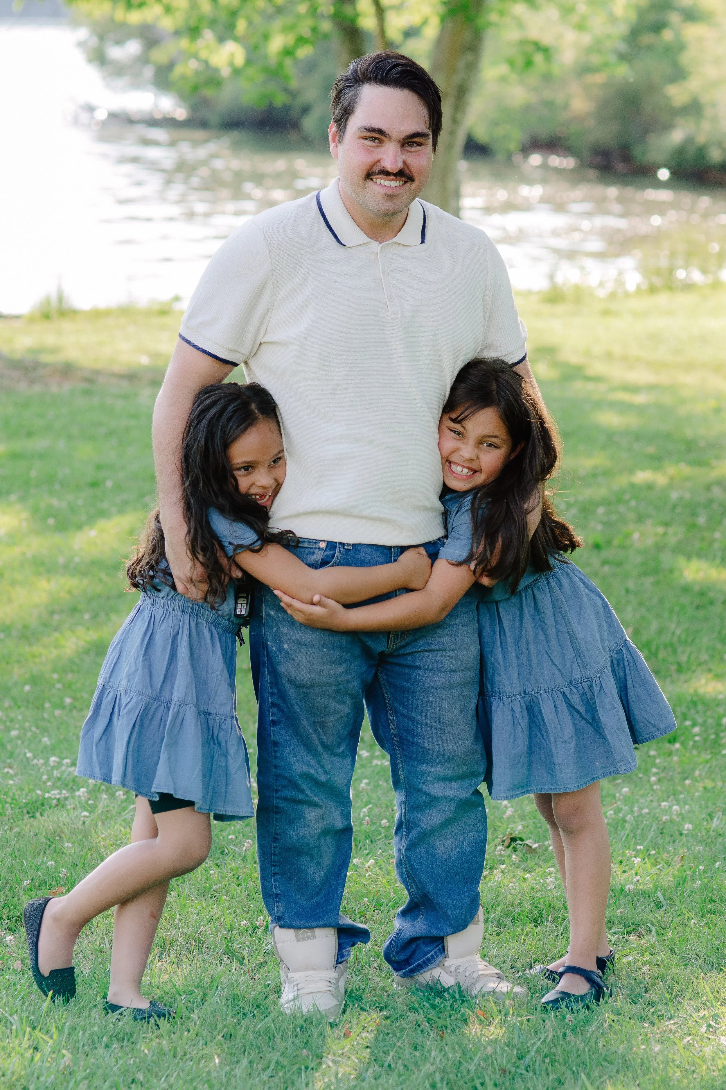 Dad playing with hid daughters during a relaxed family session at Melton Hill Park in East Tennessee