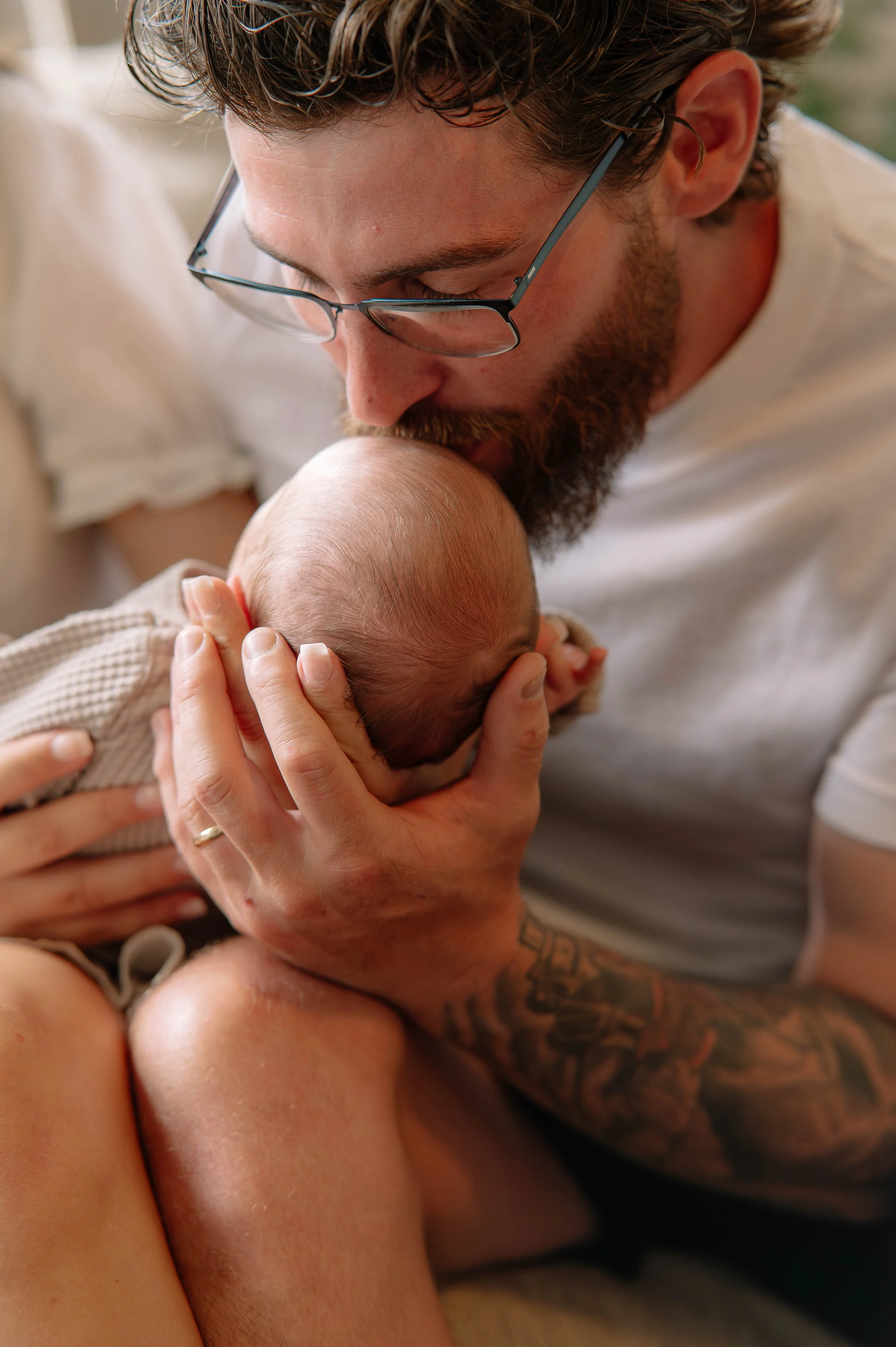 Dad kissing his newborn baby during in home session in Maryville, Tn