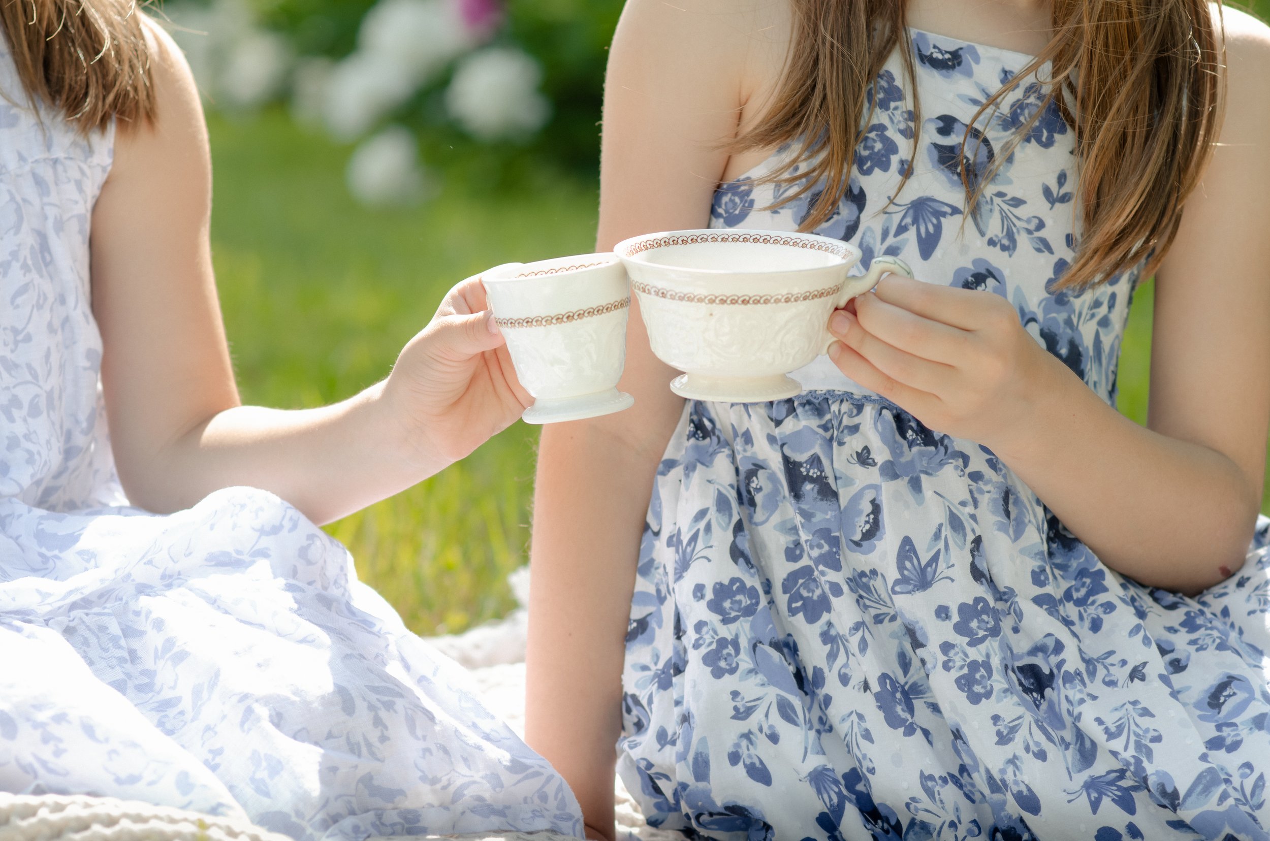 Sisters photos in Knoxville with tall trees and natural, playful tea party photo session.