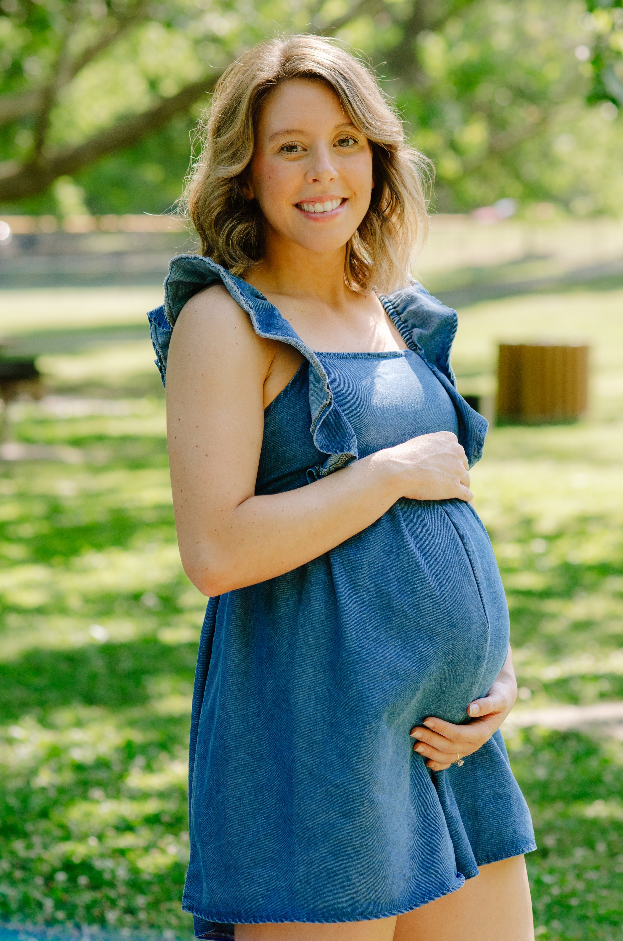 Expecting mother holding her baby bump during a sunset maternity session in Maryville
