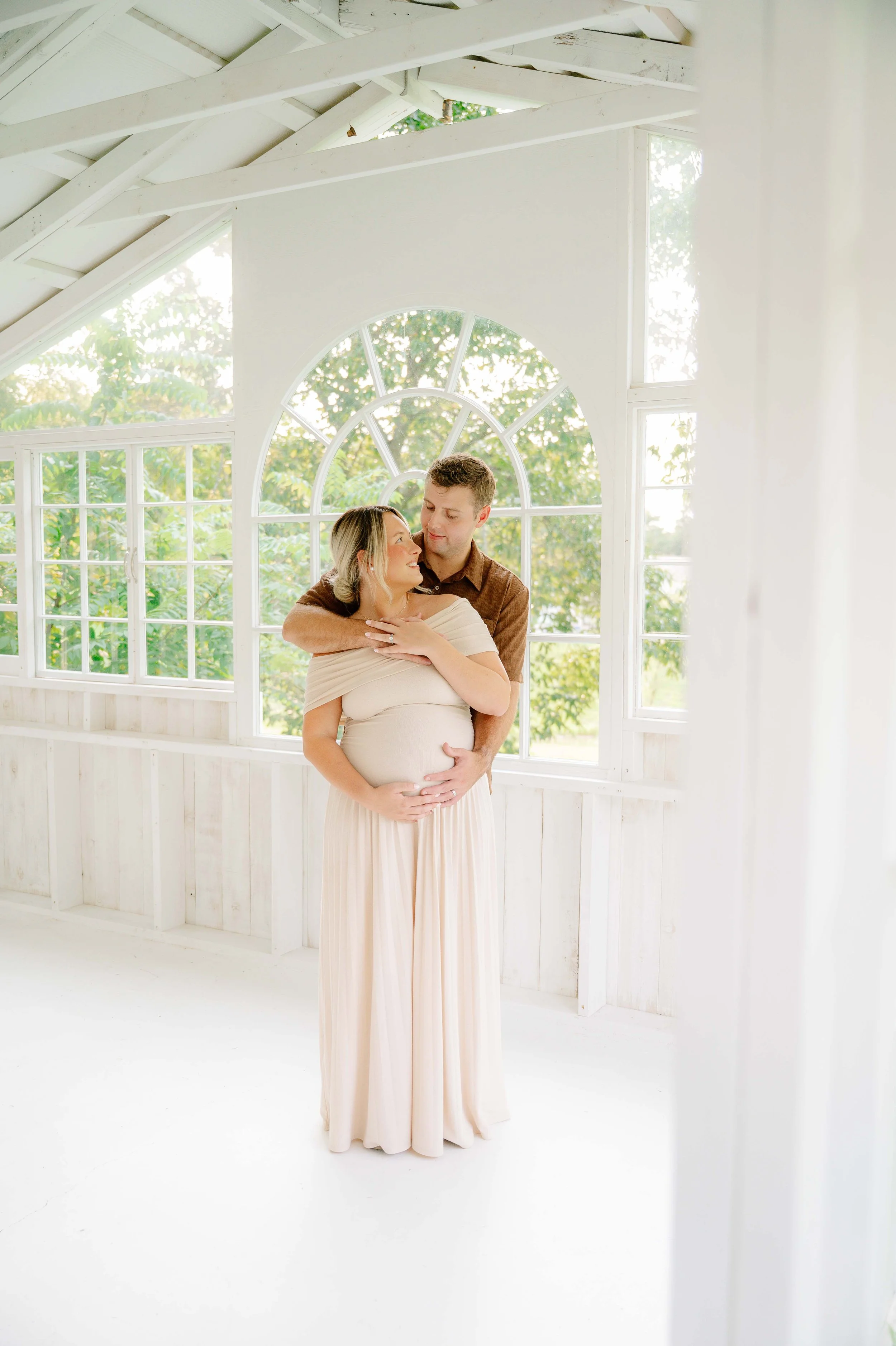 Couple embracing at The Holmstead Studio during maternity session captured by a maryville photographer