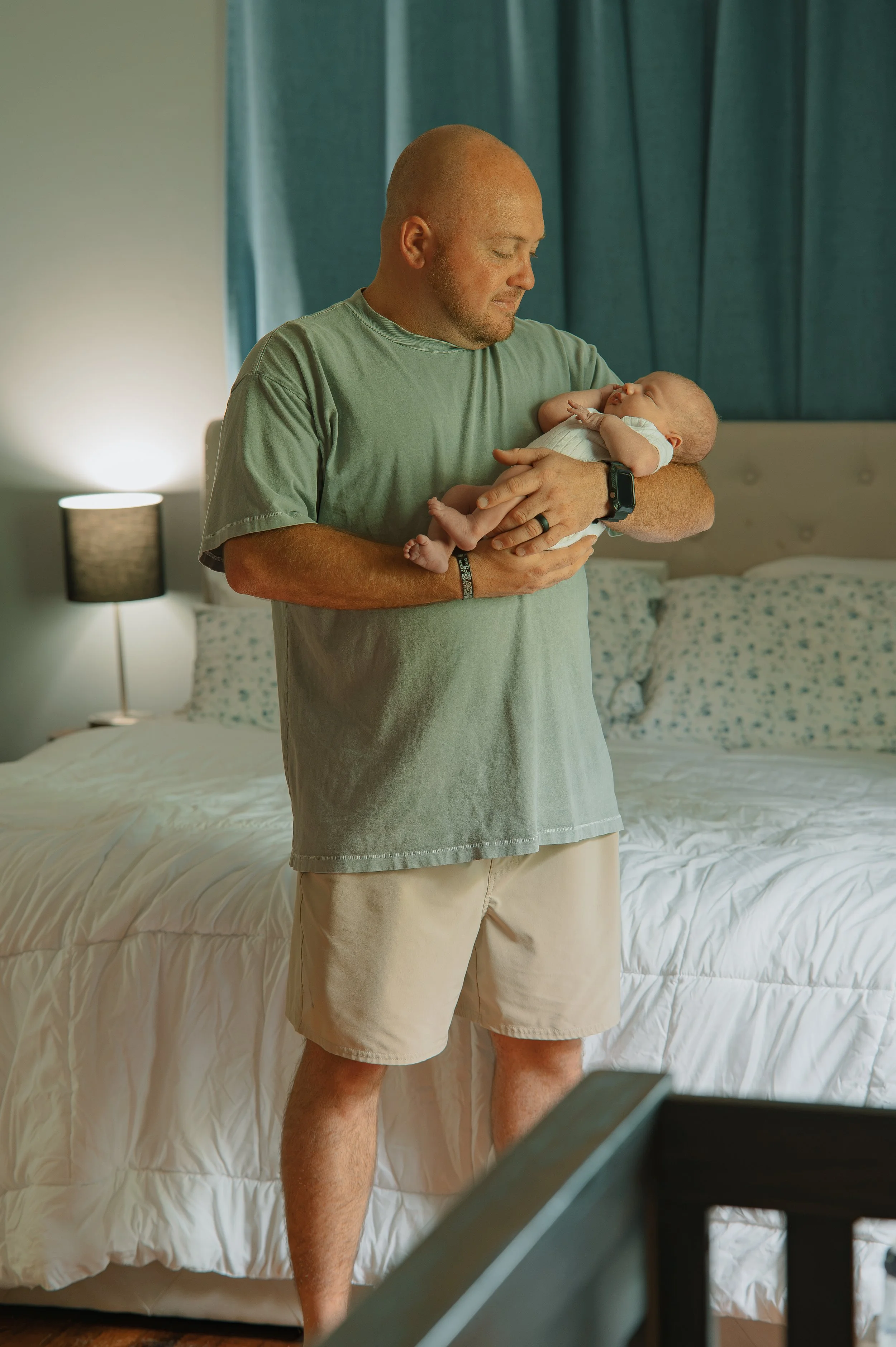 Maryville newborn photographer capturing genuine moments between new parents and their baby