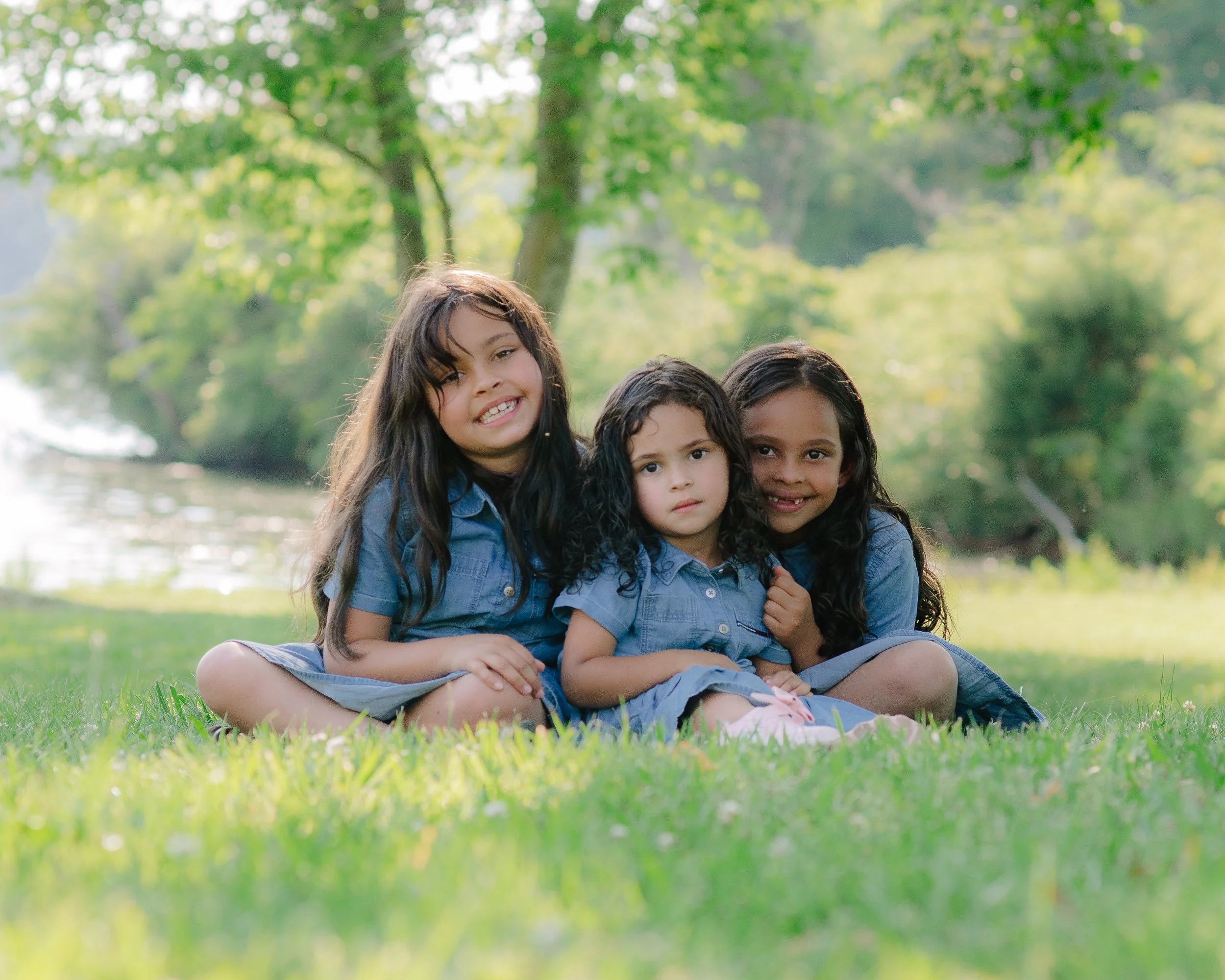 siblings embracing together during golden hour at Melton Hill Park with their newest addition