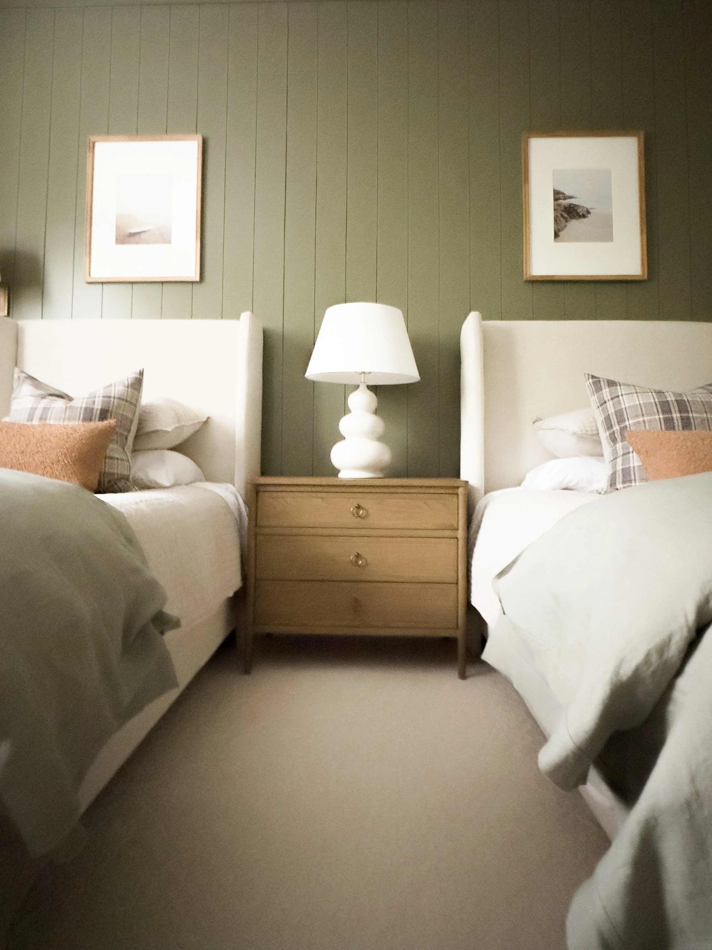 Twin bedroom with tweed beds, oversized nightstand with triple gourd lamp. Sage, oatmeal, cognac and plaid bedding. Soft, sandy beach landscape photographs.