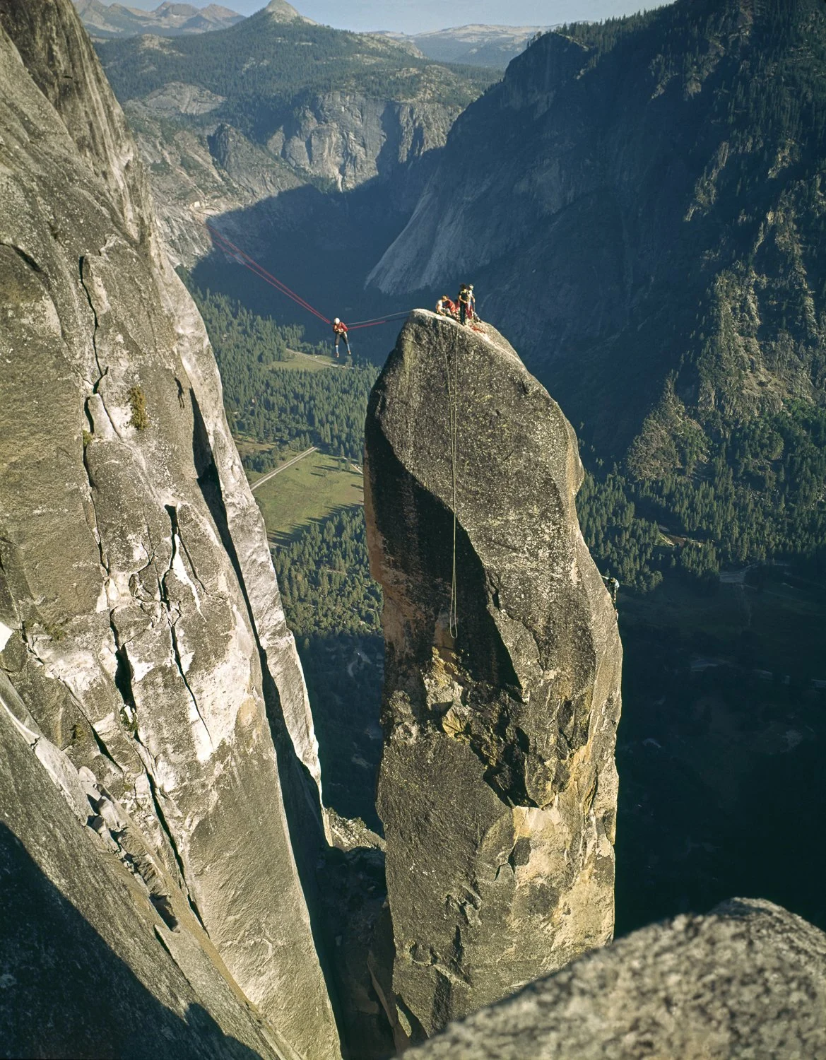 Lost Arrow 1967 CA showing climbers on a tall spire with Tyrolean traverse line above Yosemite Valley