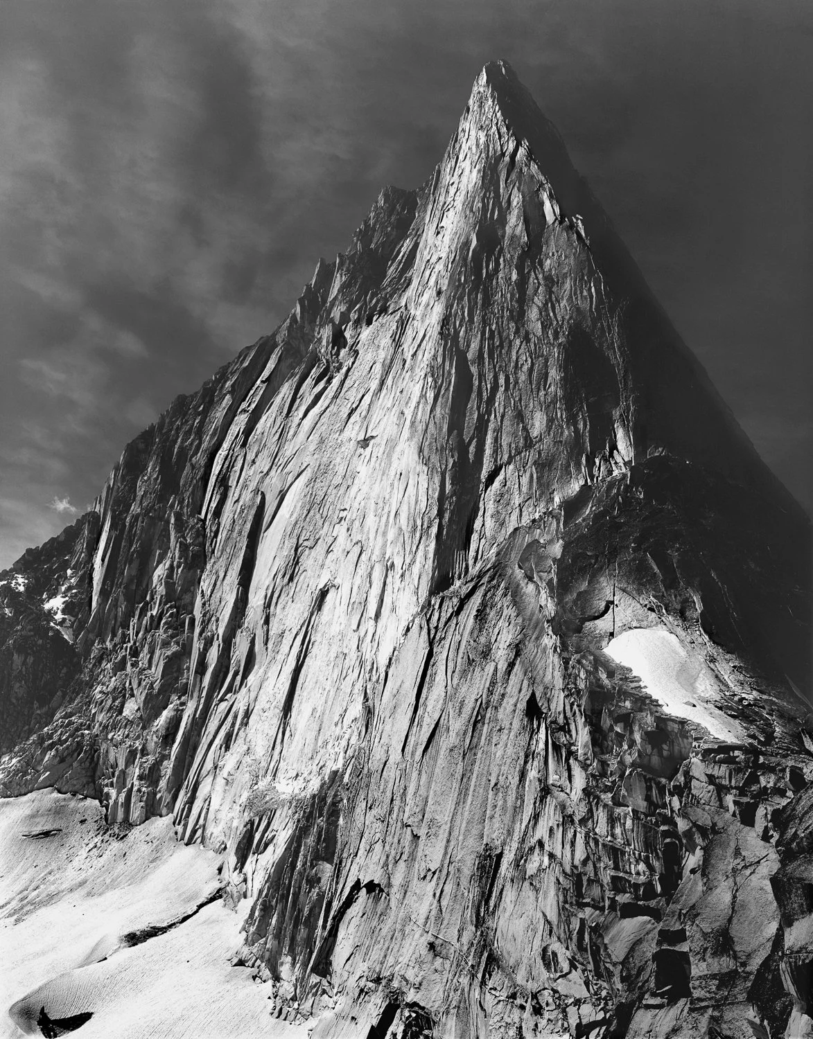A Favorite Canadian Bugaboo, 1960. This dramatic shot of the East Face of Bugaboo Spire shows the upper  third of the original Kain Route established by A.H. and E.L. MacCarthy along with Conrad Kain in 1916 on the left and the classic Northeast Ridg