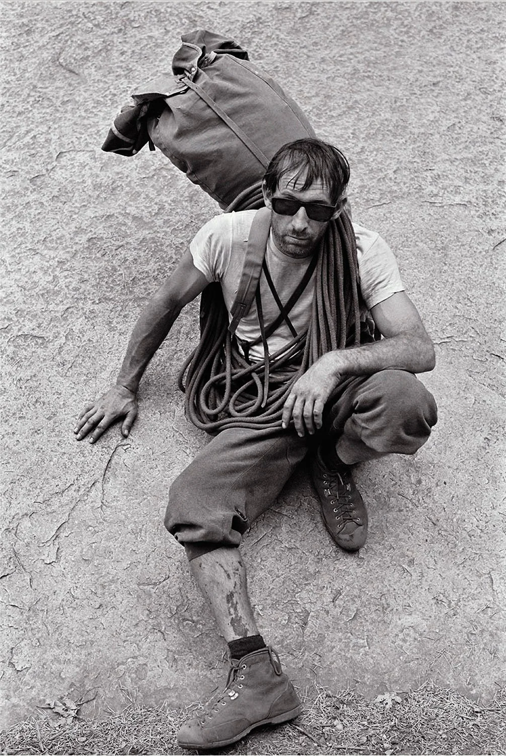 Royal Robbins After TSA Glen Denny climber seated against rock with rope and pack resting after climb