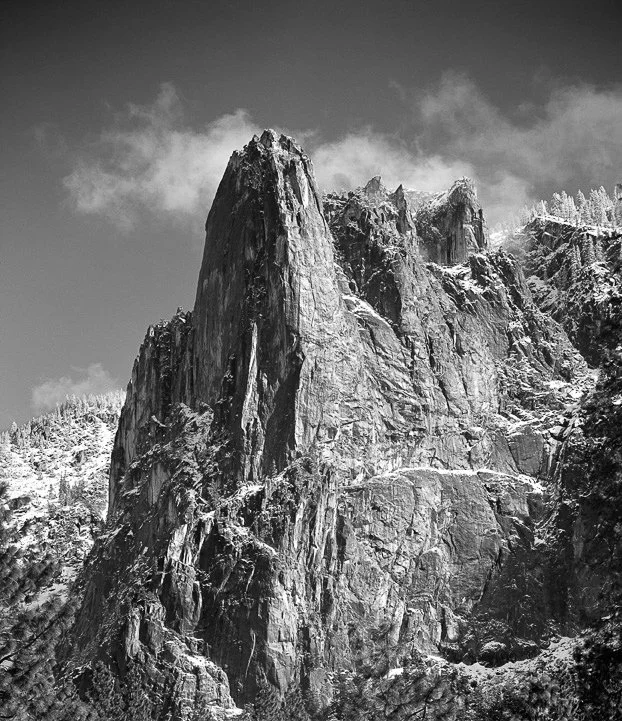 Sentinel Rock from northwest Yosemite towering granite face with snow-dusted ledges and clouds drifting overhead