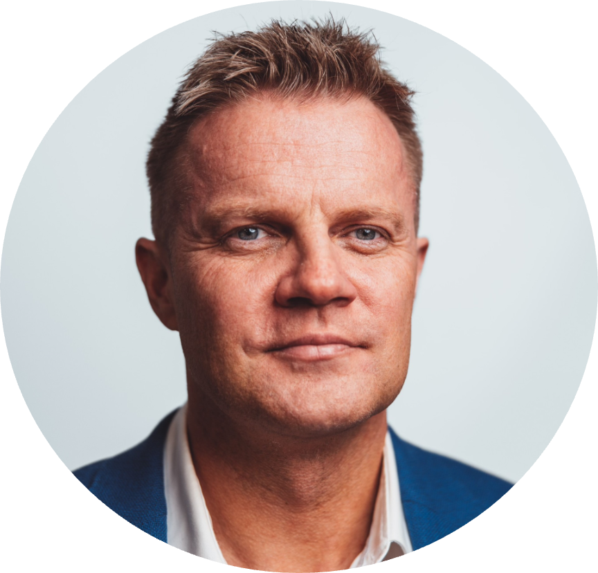 Nærbilde av en mann i dress foran en lys bakgrunn