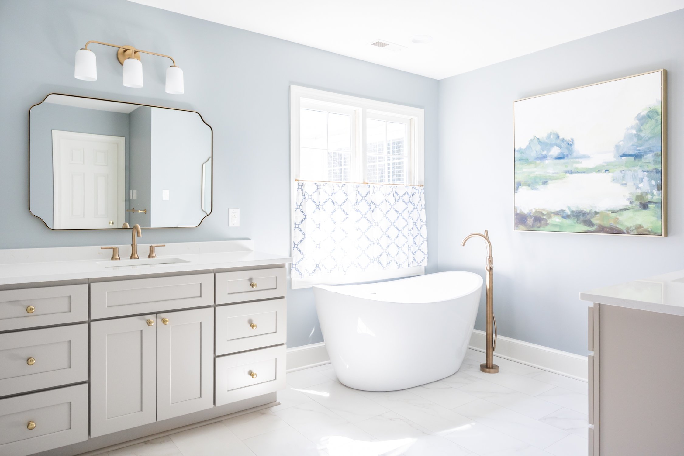 Serene blue bathroom with large art 