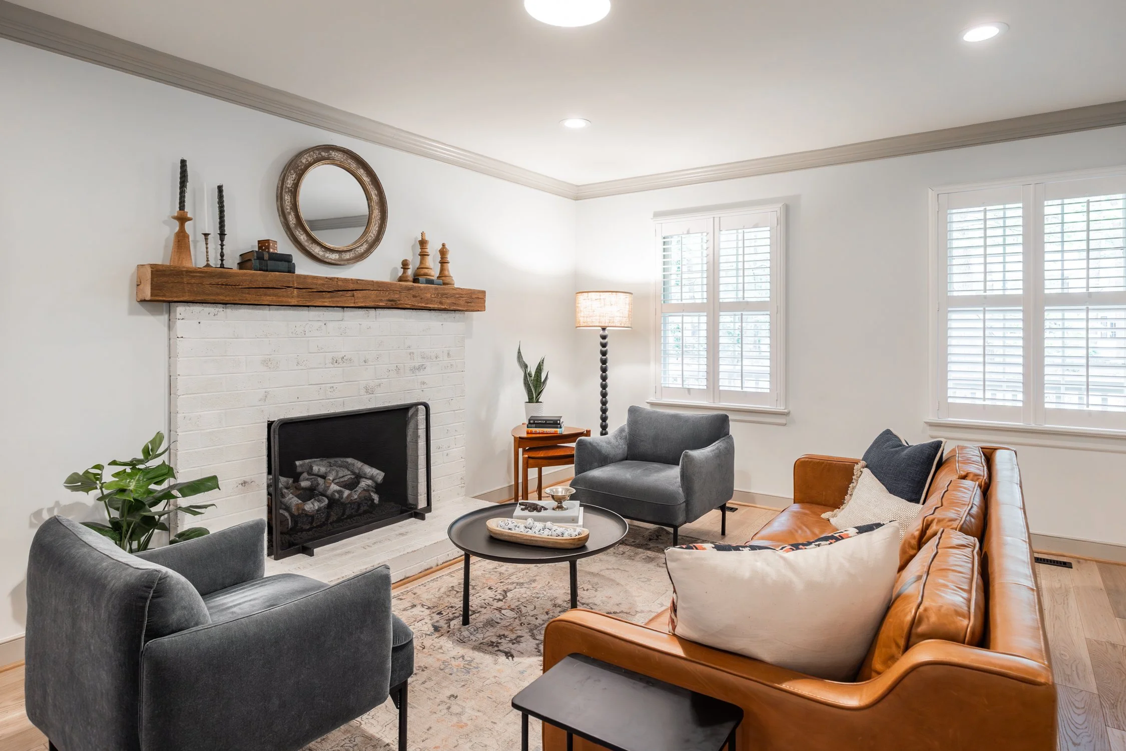 Neutral family room blending modern furnishings with brick and natural elements to create a space to enjoy year round.