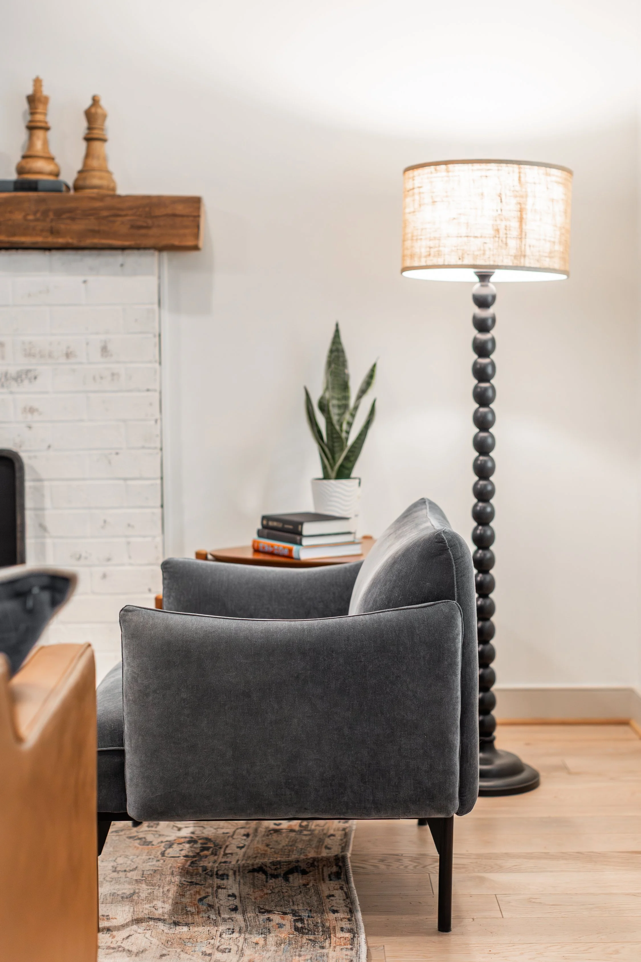 Add interest to a corner in your room with a floor lamp, chair, and plant - creating a cozy corner.