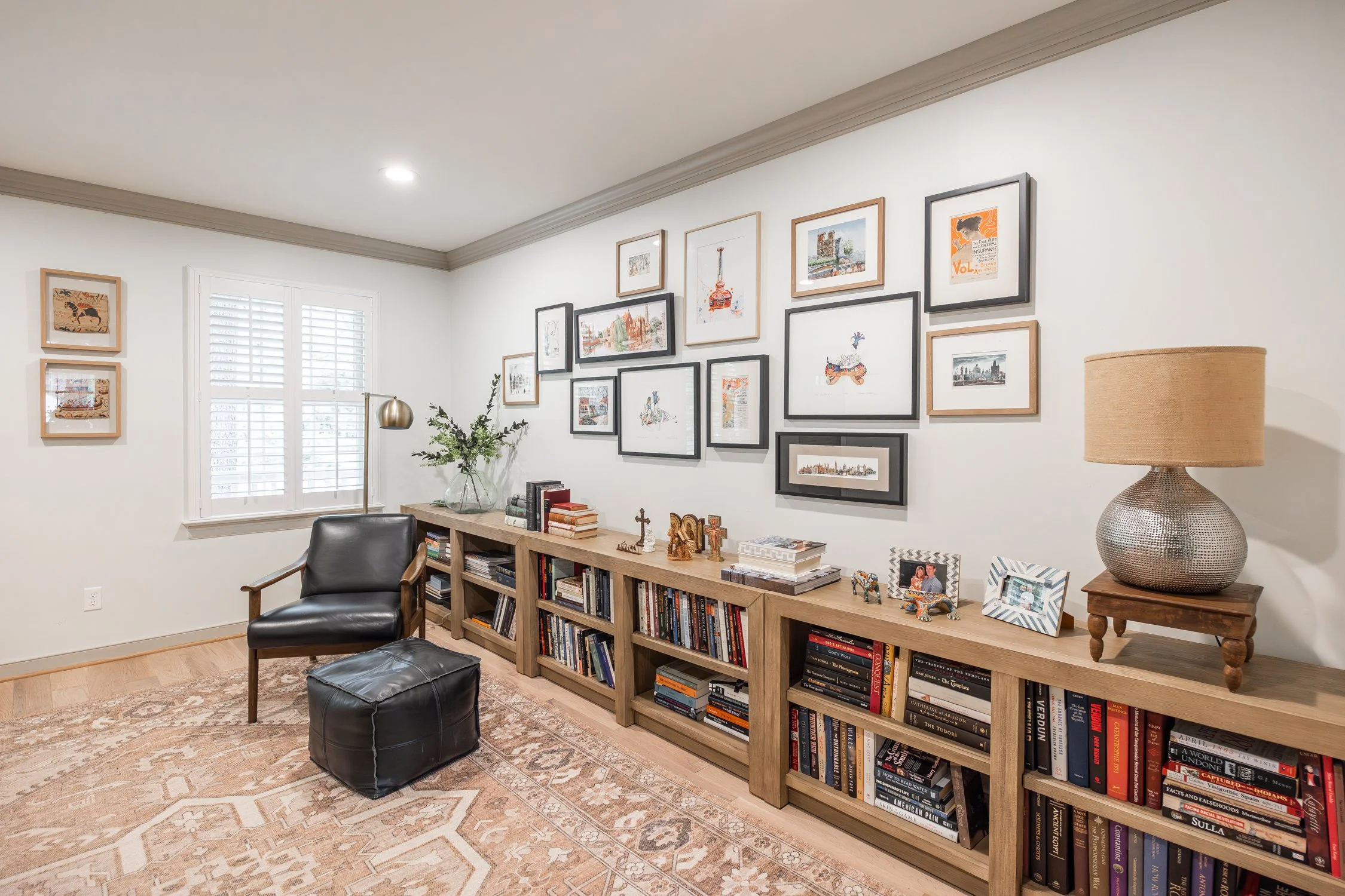 This multi purpose room offers a place to hang art collected on travels and serves as a library and office.  The gallery wall is a collection of art collected over the years and showcases different frames offering interest.