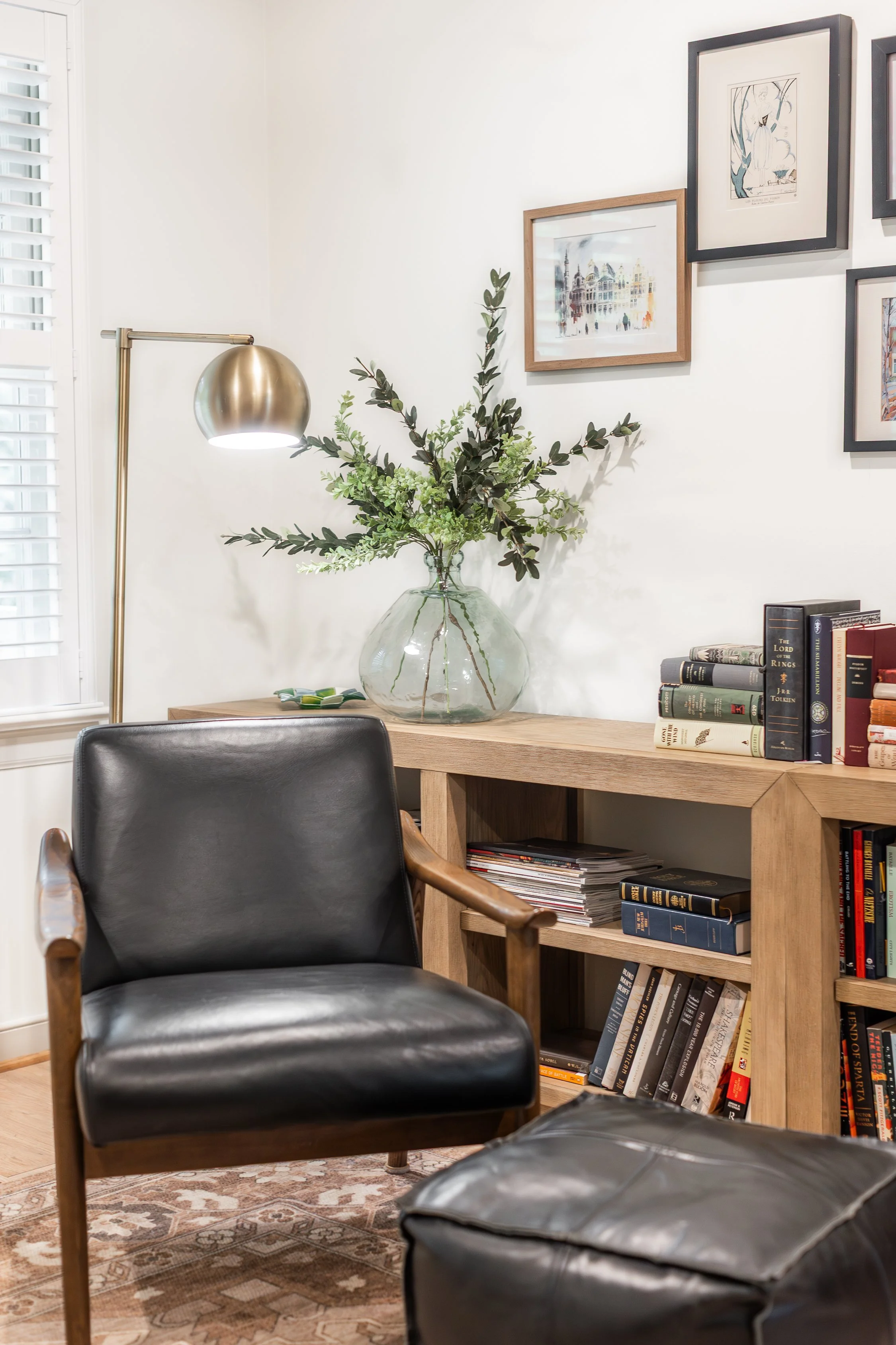 Combination of wood, leather, brass, and glass offers interest in this corner