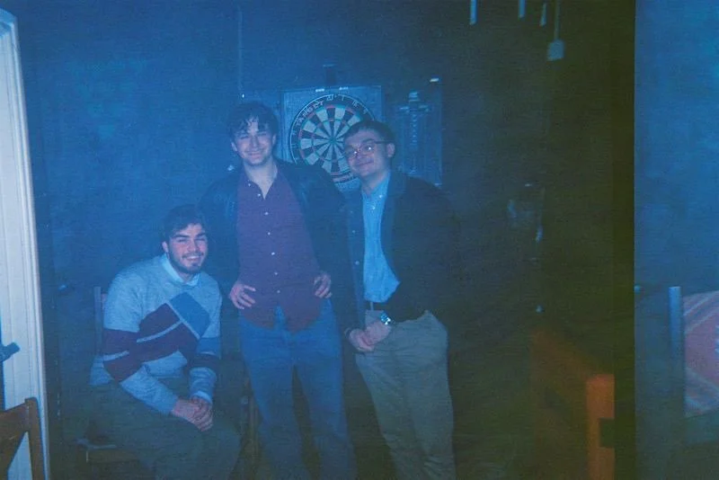 Three cast members posing in a bar