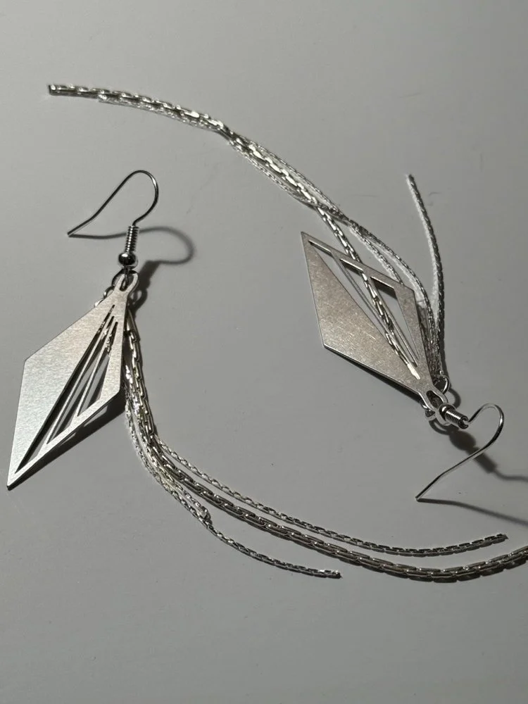 Angled overhead view showing the Art Deco diamond detail and the fall of the chains.