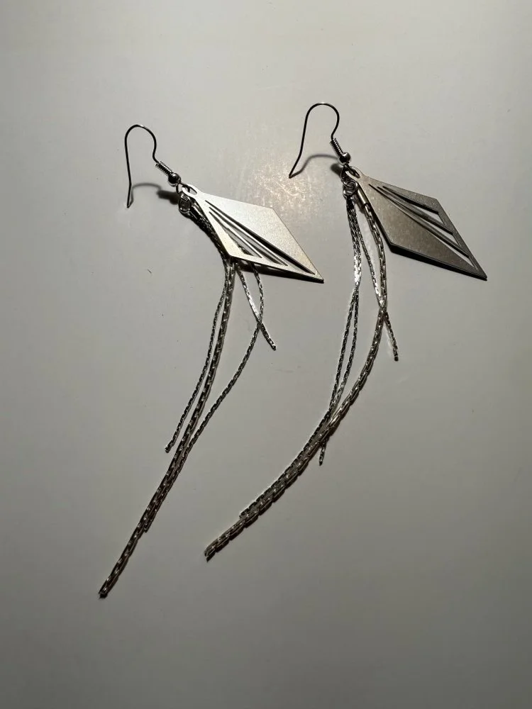 The earrings photographed flat with chains arranged to show full length and movement.