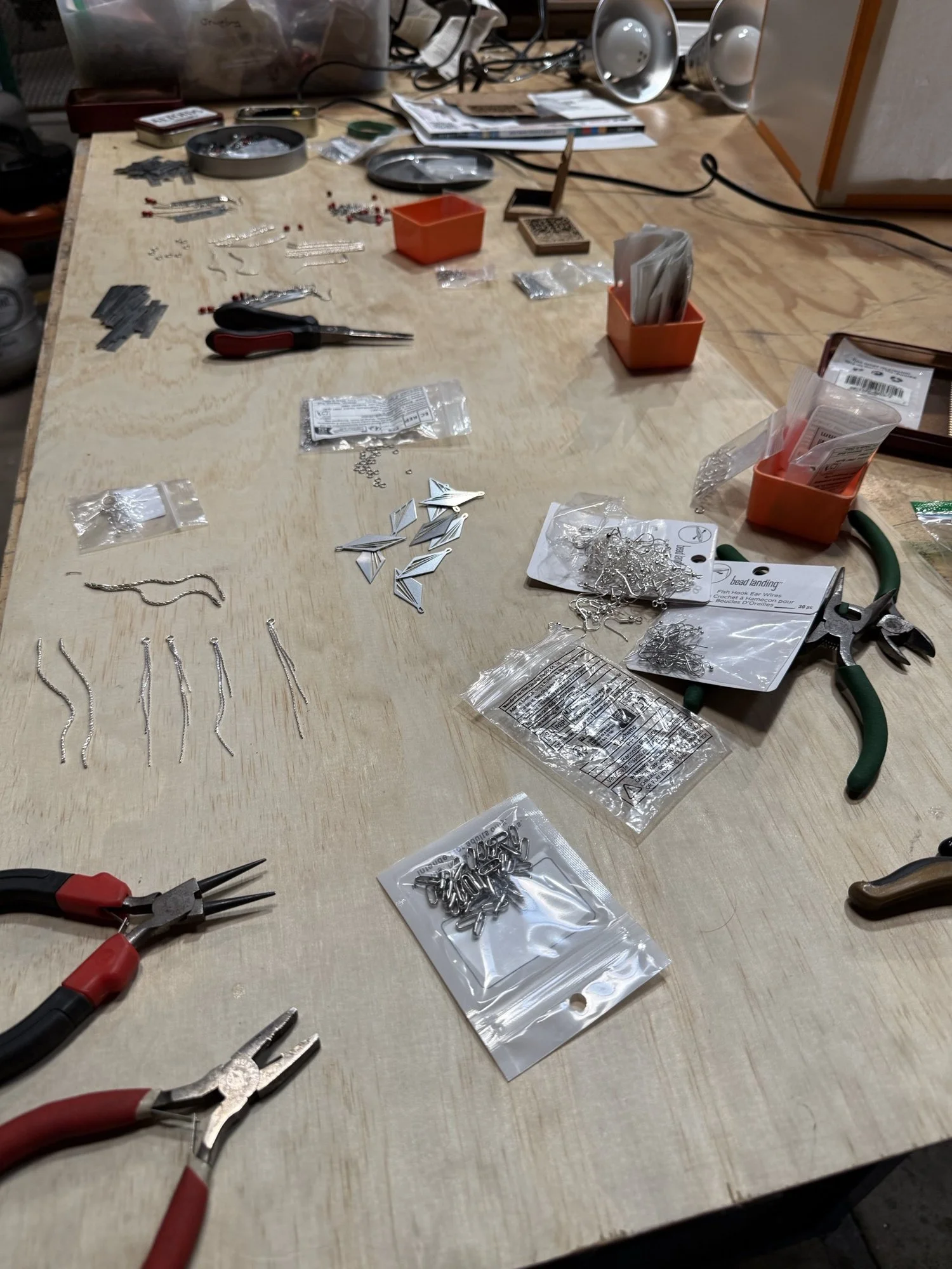 Workshop for Apotheosis Jewelry Arts showing a work table with jewelry parts, tools and notes.