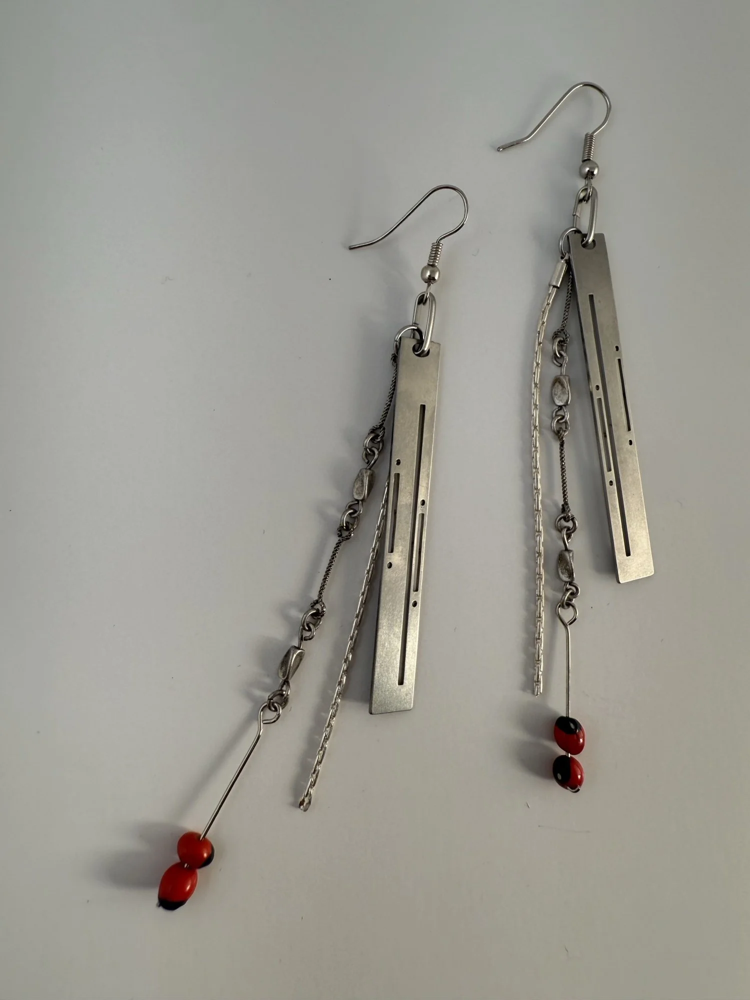 Overhead view of the earrings arranged flat, showing the geometric form and Art Deco detail.