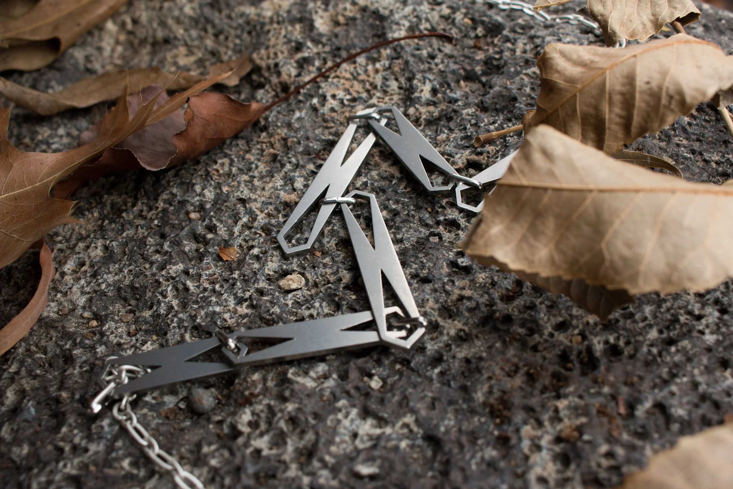 The bracelet arranged in a loose fold on stone, showing the flexibility of the linked construction.