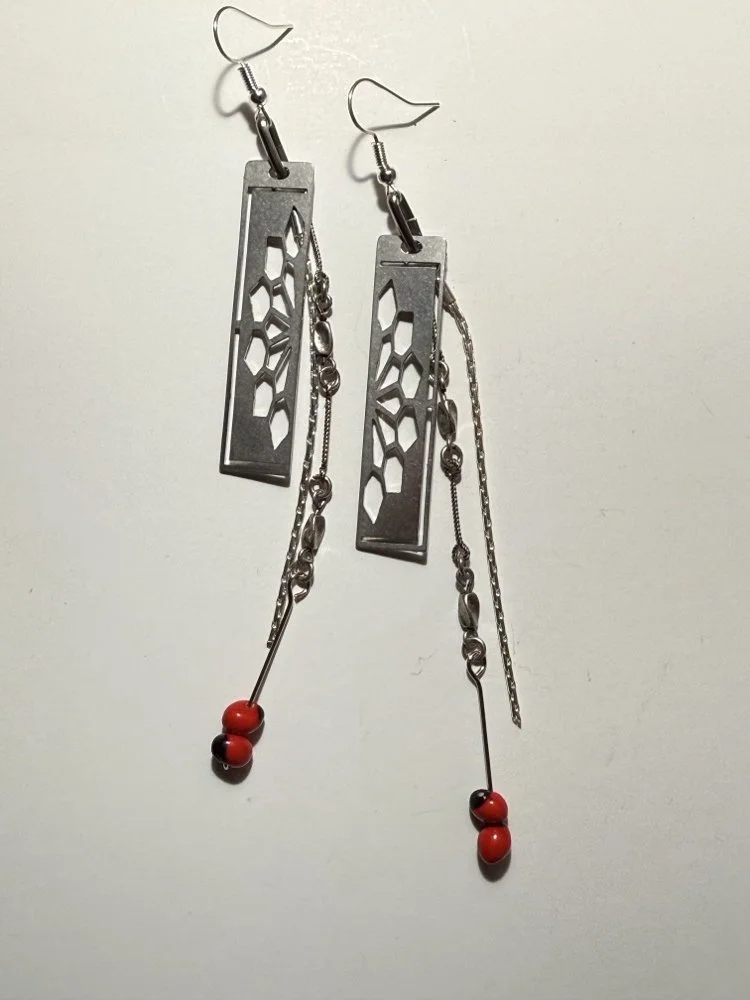 The earrings laid flat, showing the full length of the chain and the red beads at the drop. (Copy)