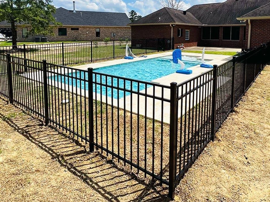 Flat top 3 rail black aluminum fence installation around pool.