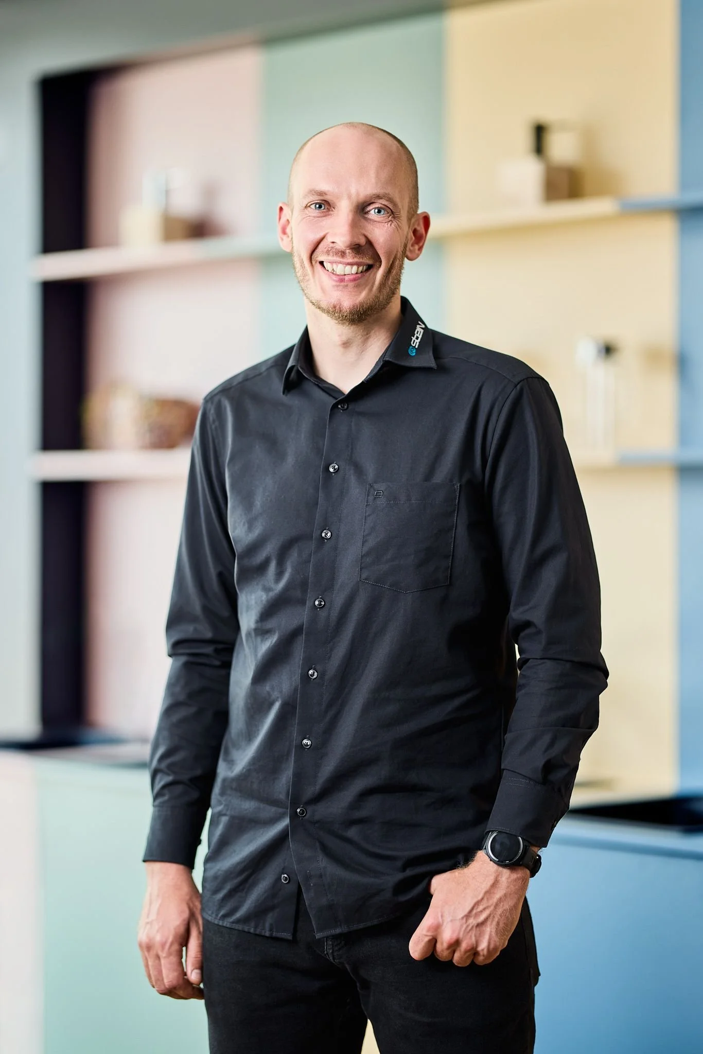 Geschäftsdführer Felix Bertram in einem Raum mit bunten Wänden und stilvollen Regalen im Hintergrund.