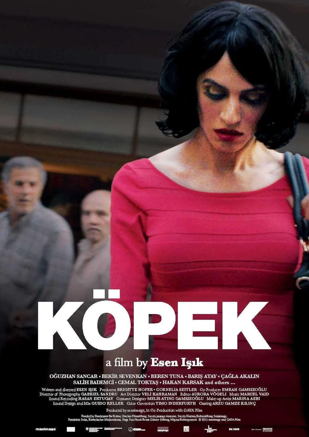 A woman with dark hair and a red dress looking down, with three men in the background looking at her in shock.
