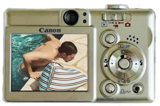 The photo shows the back of a Canon point-and-shoot camera, with the LCD screen displaying an image of a man leaning over a woman by a pool.