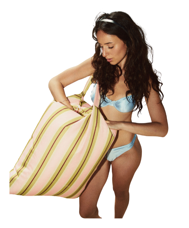 Woman in blue lingerie carrying a large striped bag.