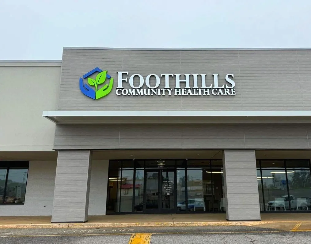 Exterior view of Foothills Community Healthcare building with logo featuring a house and leaves.