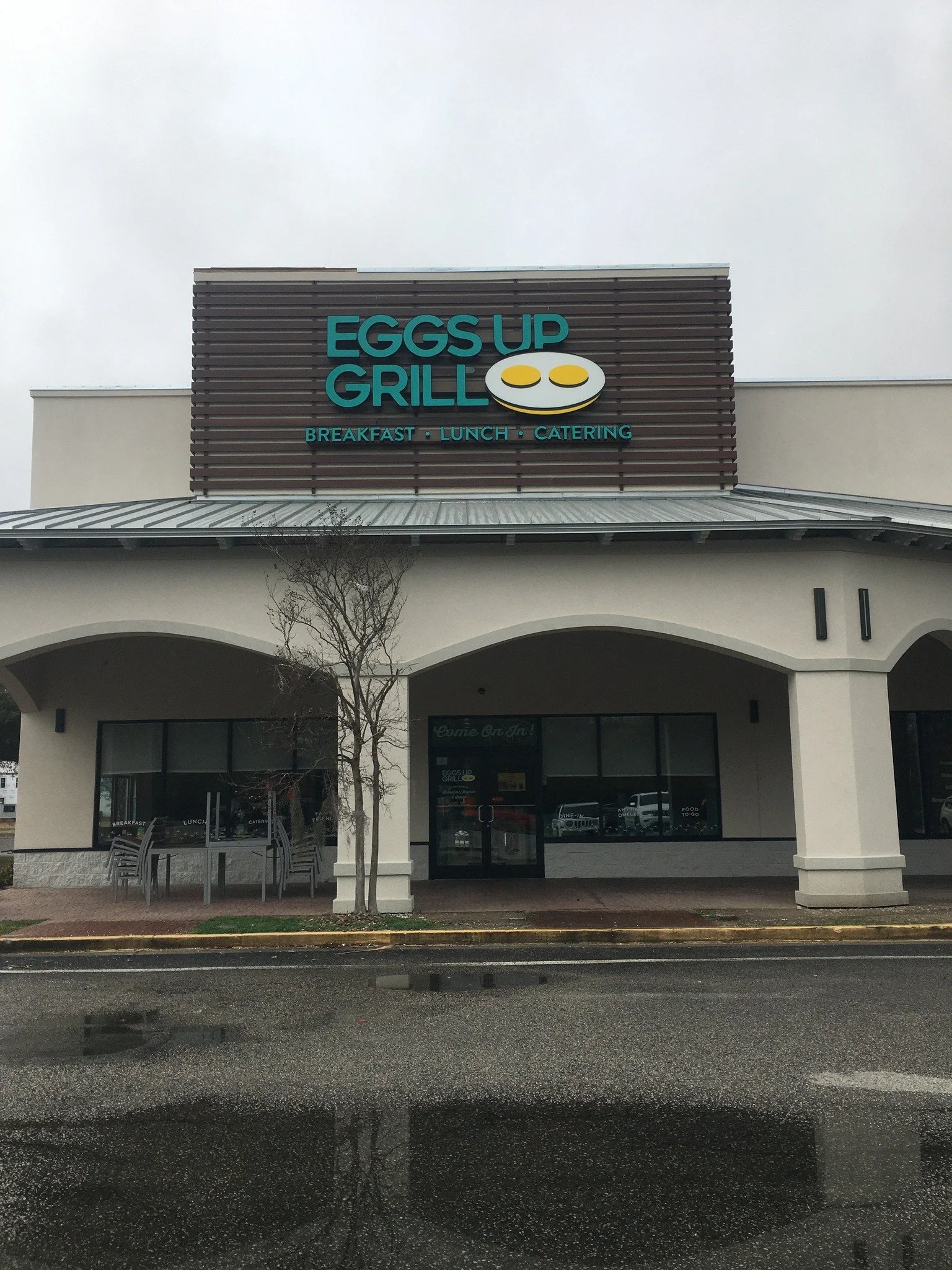 Exterior view of a restaurant named Eggs Up Grill with a sign showing eggs and three words: Breakfast, Lunch, Catering.