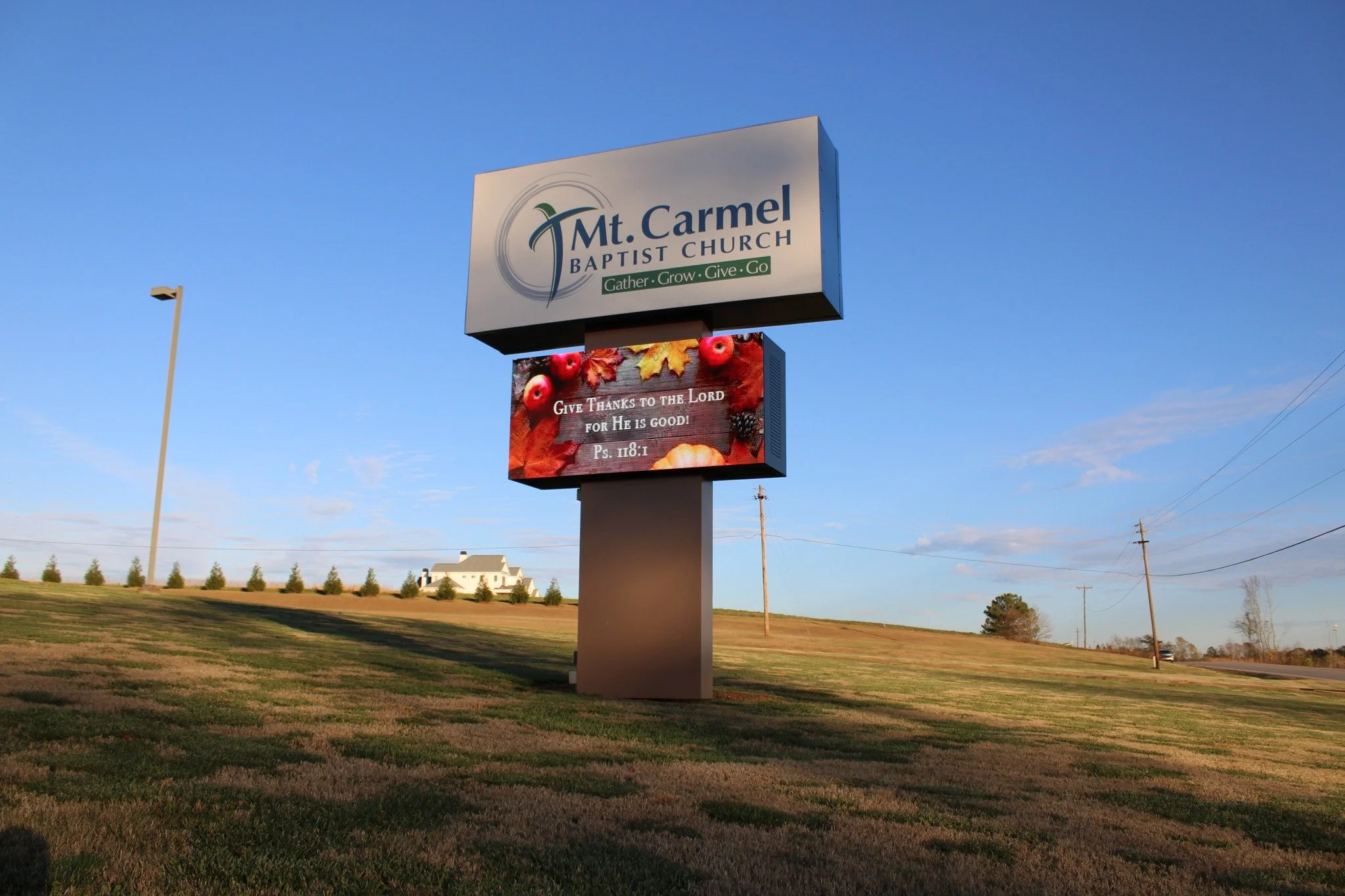 Sign for Mount Carmel Baptist Church with an additional digital sign displaying a Bible verse about giving thanks.