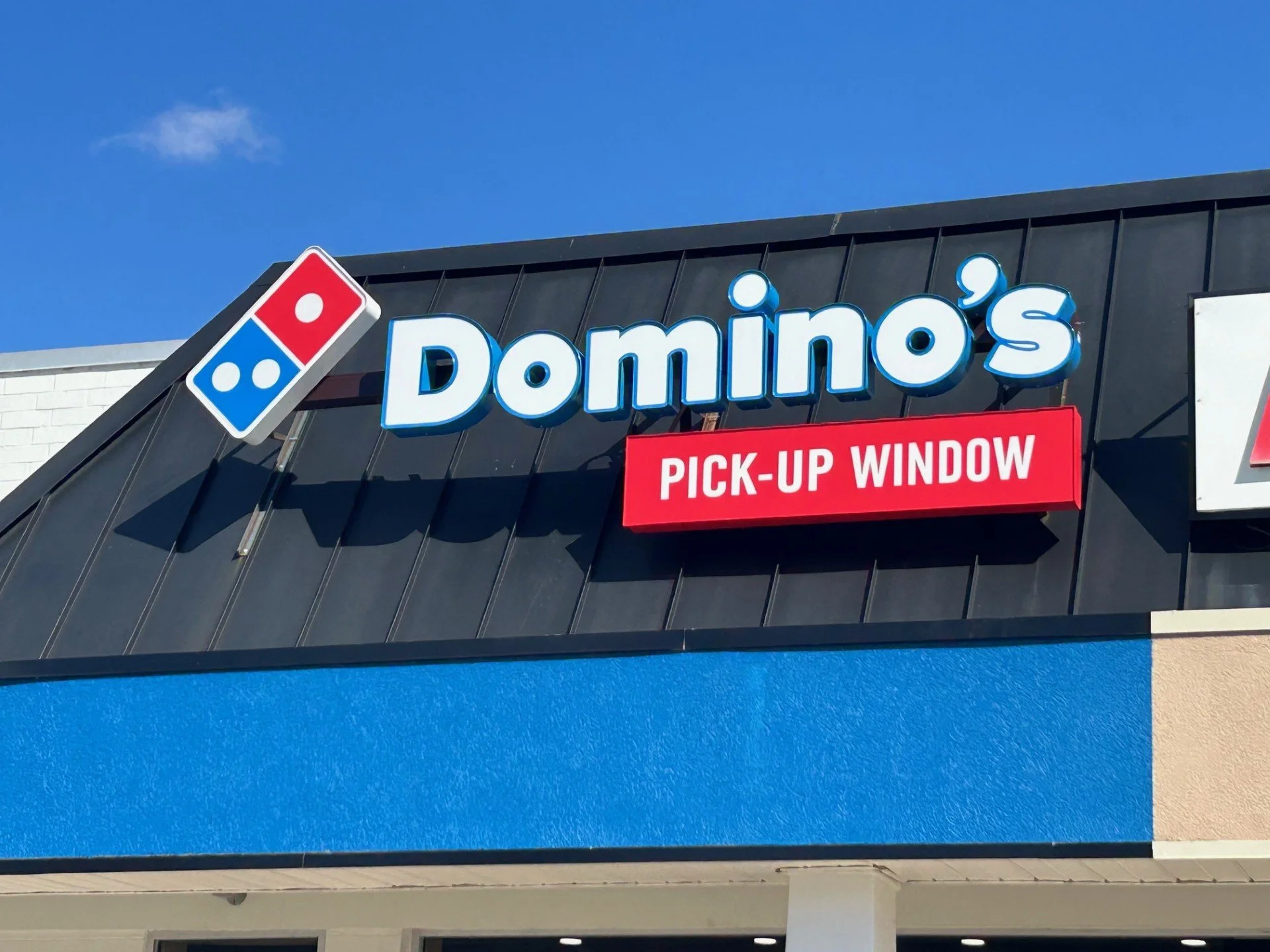 Exterior of a Domino's Pizza restaurant with a sign that reads 'PICK-UP WINDOW'.