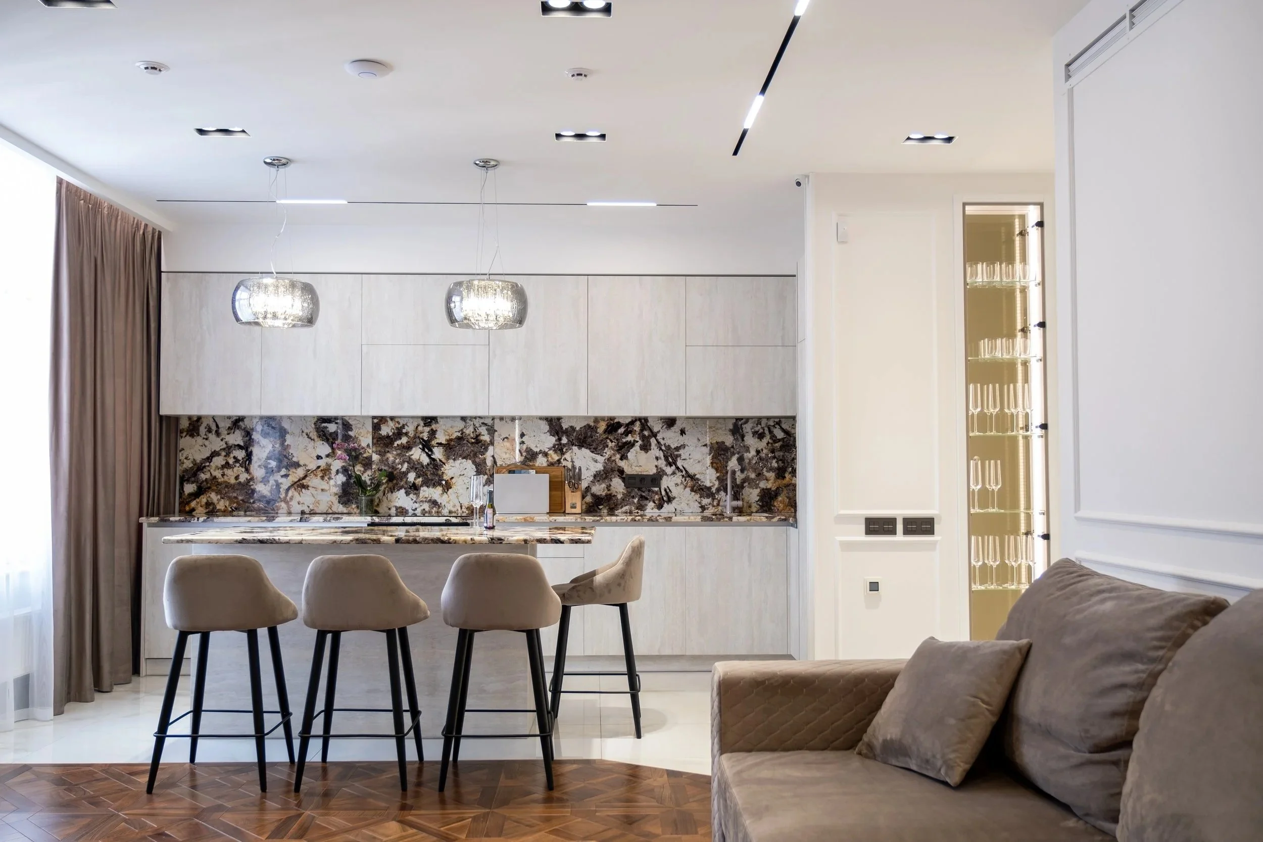 Interior photography of modern open-concept kitchen and living room, Niagara region, natural light, marble island, neutral tones