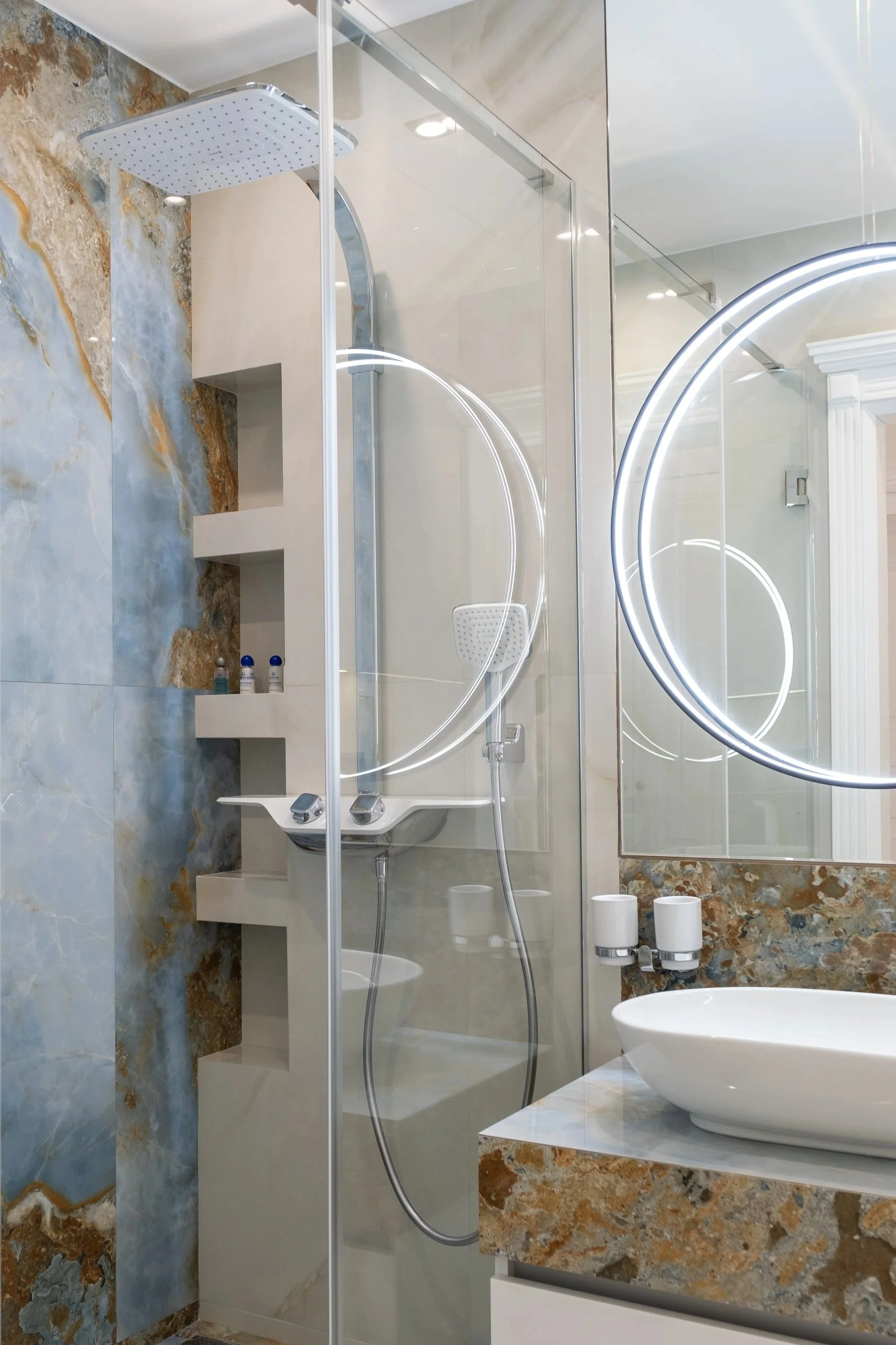 Interior photography of modern bathroom, marble walls, walk-in shower, backlit mirror, Niagara Ontario
