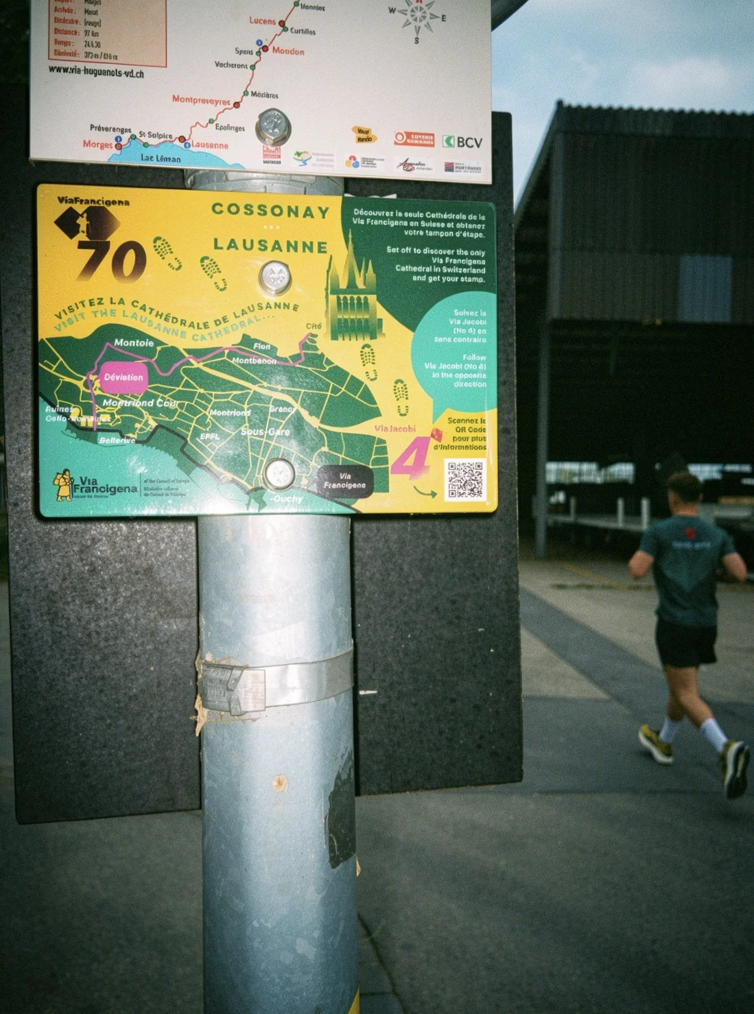 Panneau d'information touristique à Lausanne, Suisse, indiquant le trajet de la Via Francigena, avec une carte de la ville et des instructions pour obtenir un tampon pour la cathédrale.
