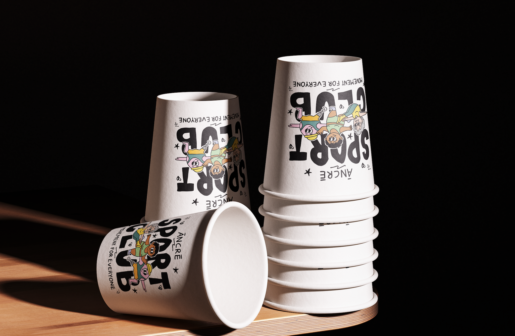 Gobelets en papier empilés avec un design coloré sur un fond noir, sur une surface en bois.