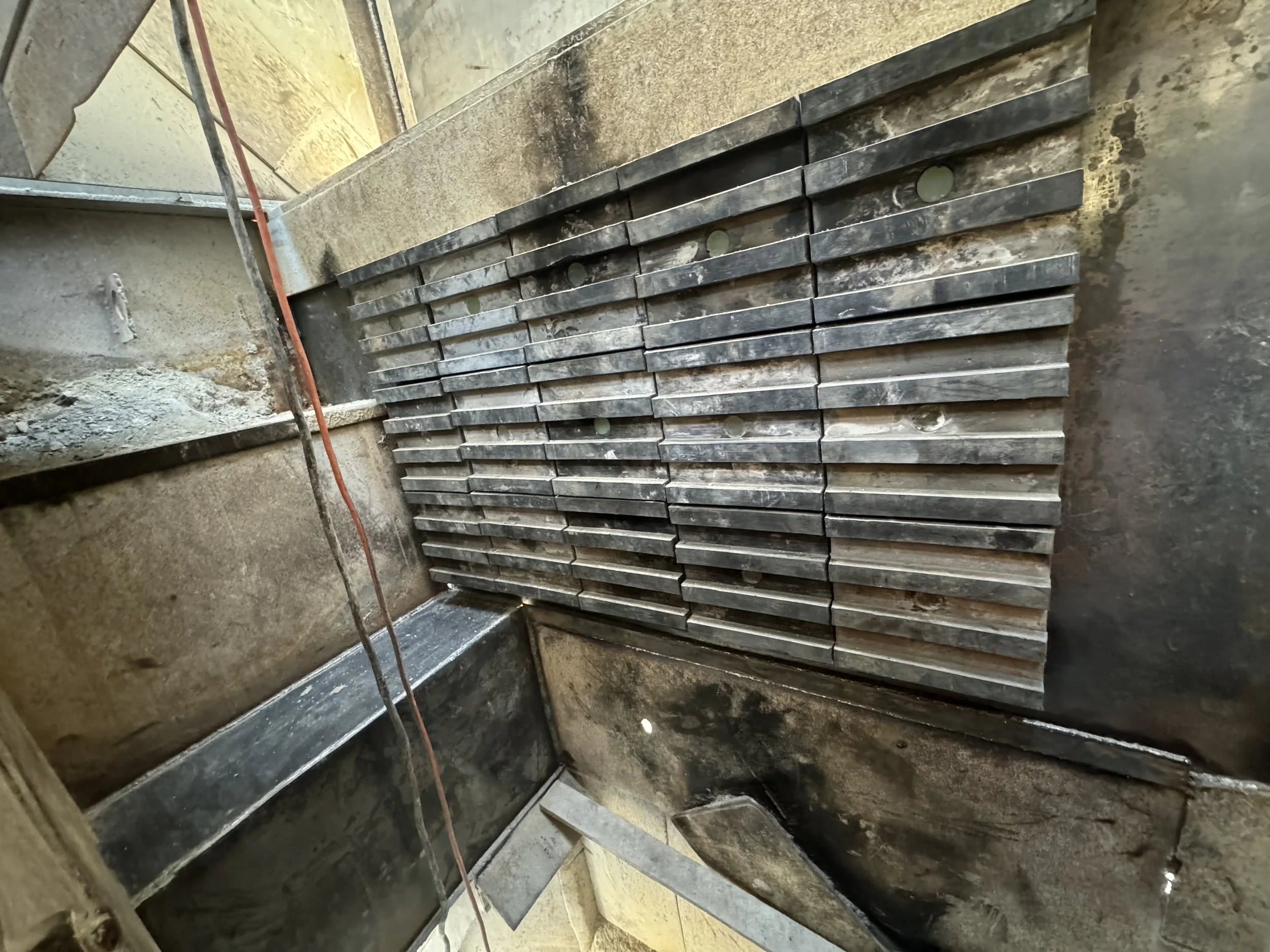 Construction site with metal bars and concrete walls under construction.