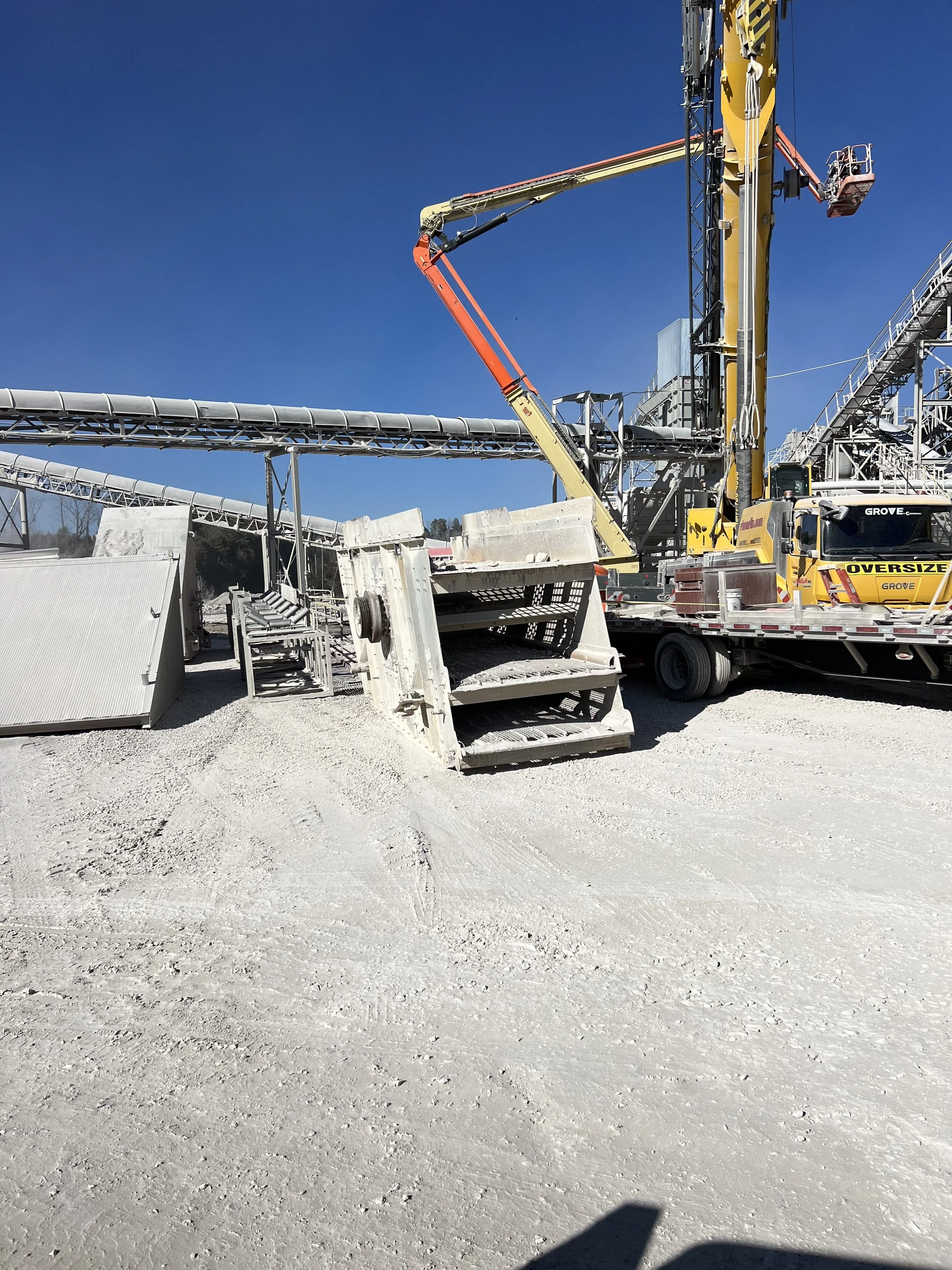 Construction site with heavy machinery and equipment on a clear day with a blue sky.