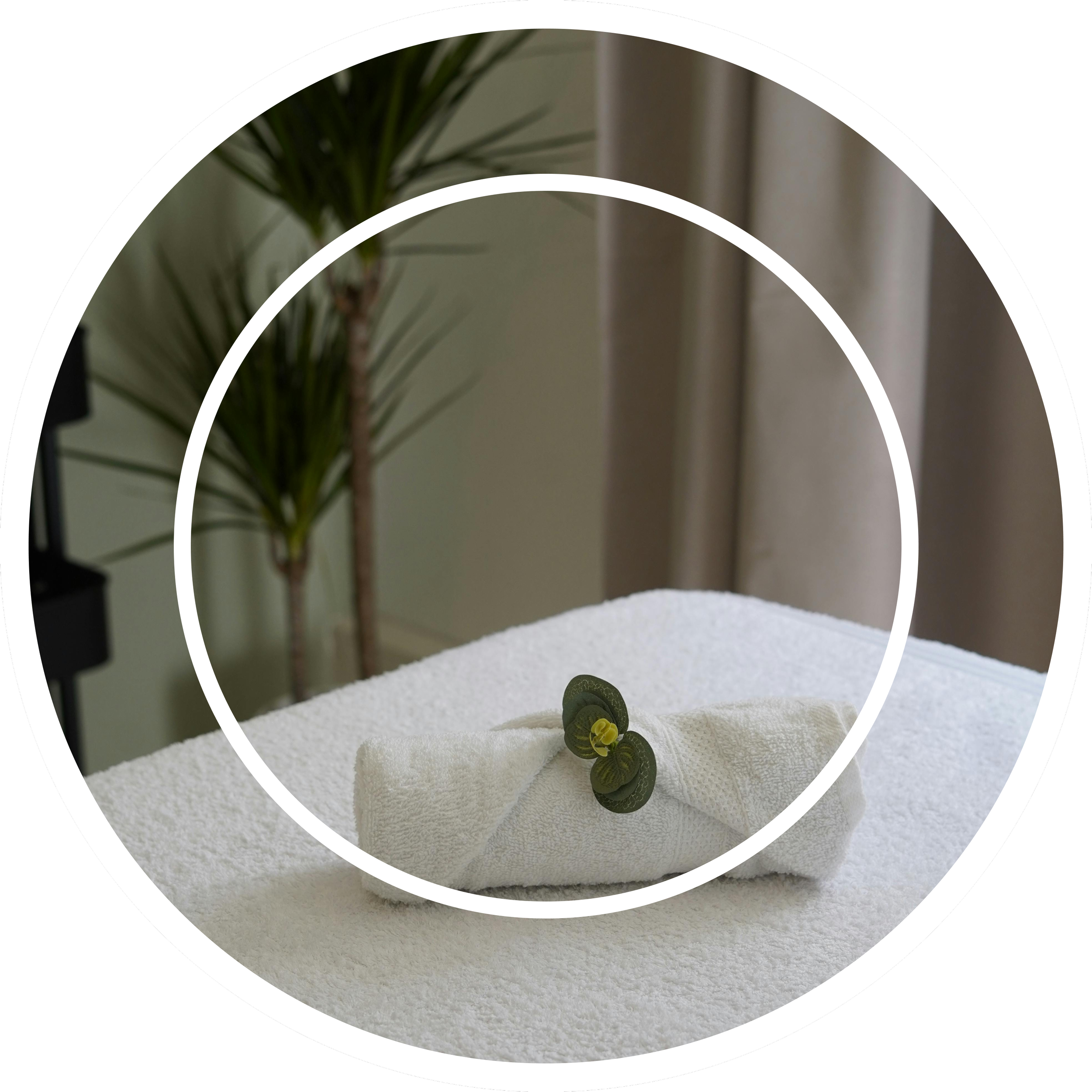 Massage bed with a clean, rolled up towel on top.
