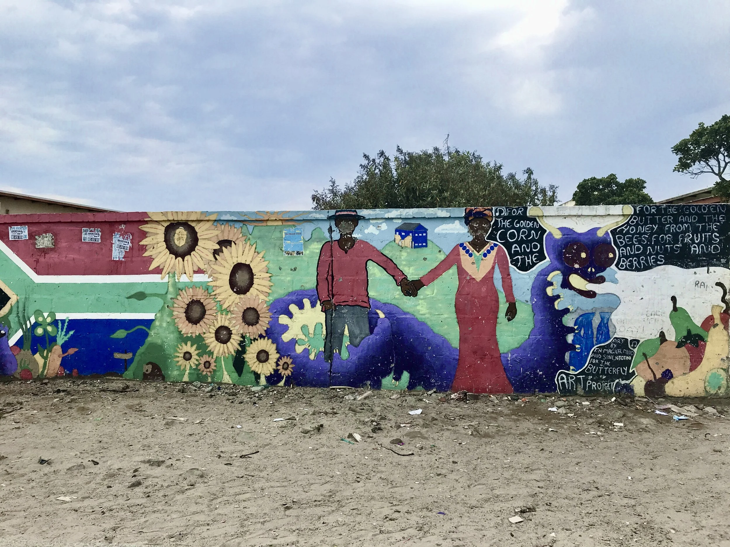 Graffiti von einem Paar die Händehalten, Sonnenblumen und der Flagge von Südafrika. Es drückt Stärke, Wachstum und Zusammenhalt aus.