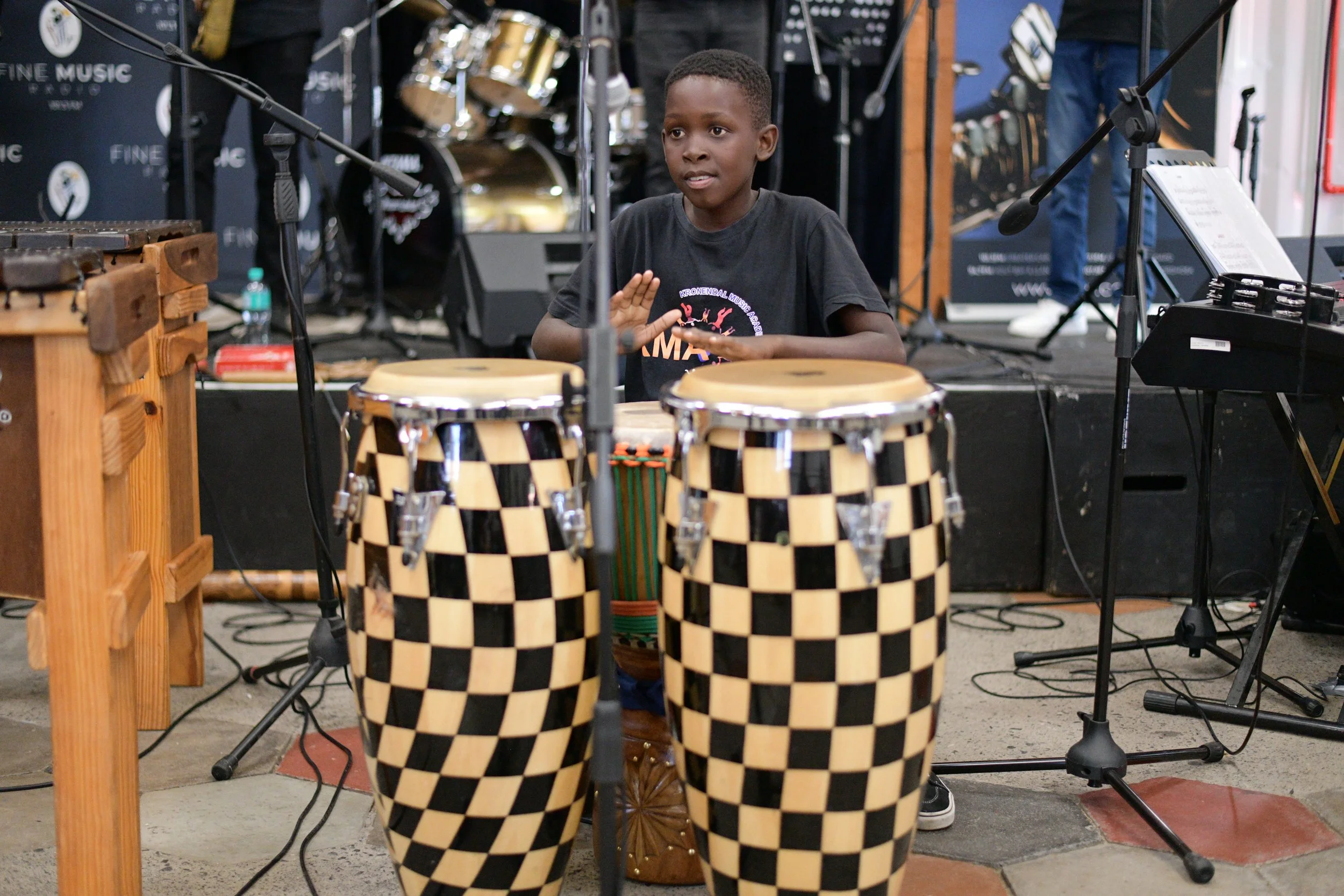 Ein Junge spielt Trommeln an einem Konzert.